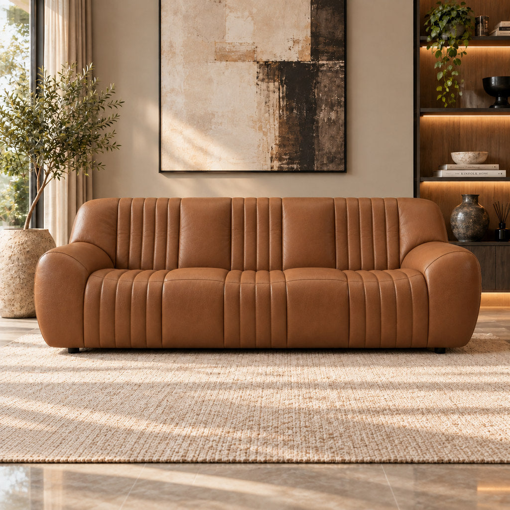 Stattera Cadence Leather Couch in Vintage Cognac, featuring warm tan leather with vertical channel tufting in a modern living room.