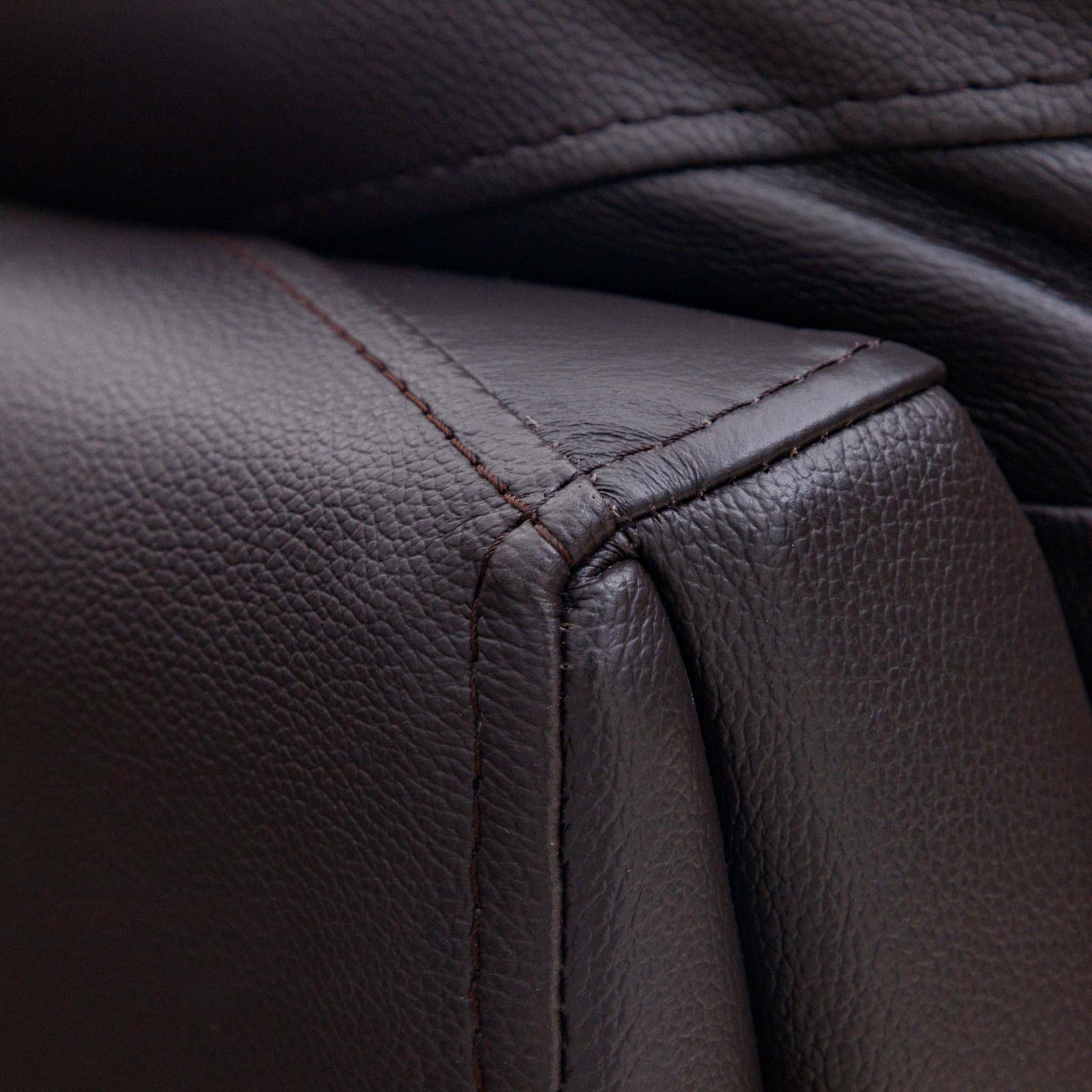 Close-up of the Leather Gallery Cairo 1 Seater Leather Recliner in Choc, showing the pebbled leather armrest, precise stitching, and corner seam.