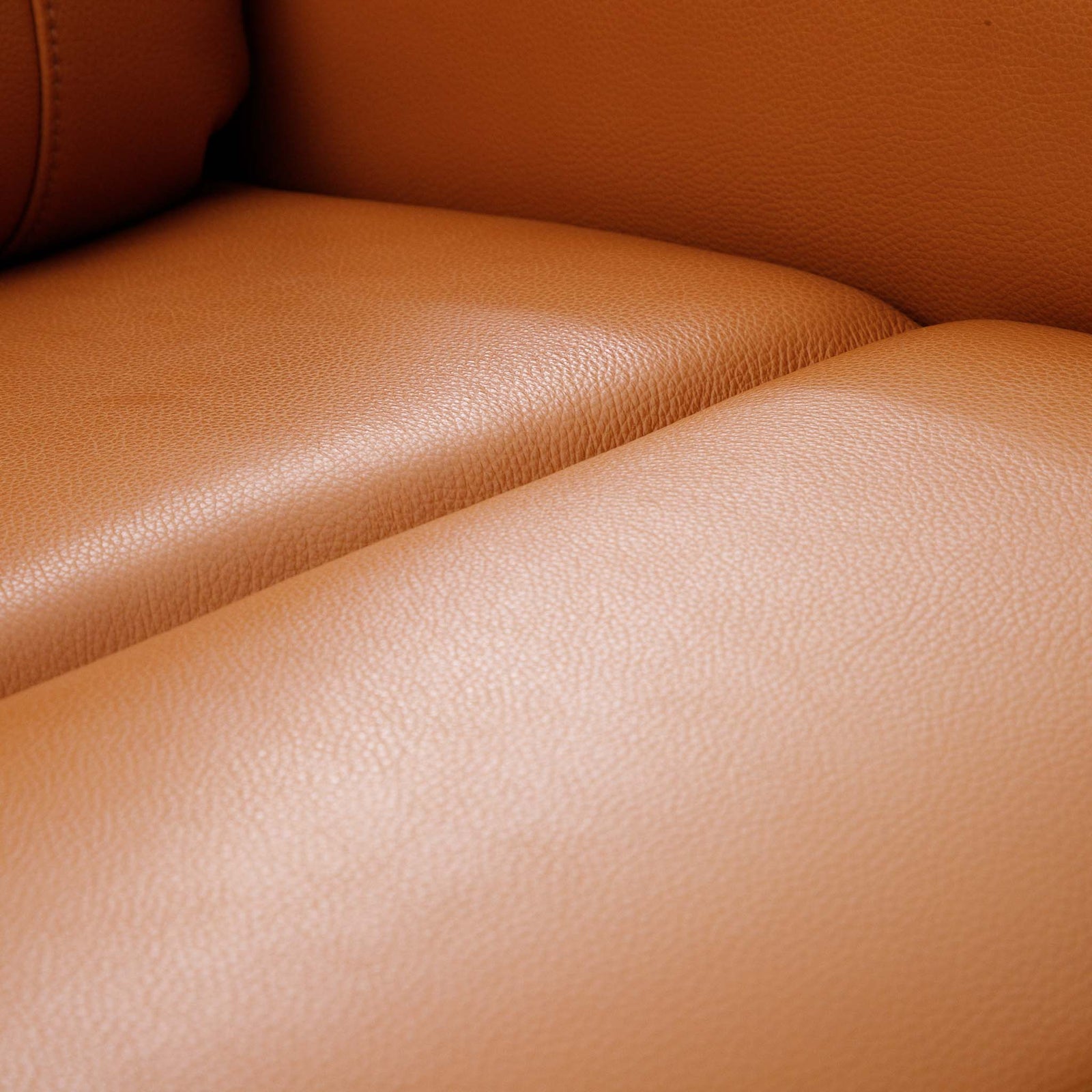 Close-up of the Leather Gallery Carter 1 Seater Leather Recliner Chair in Tan, showing the pebbled leather texture and curved contours.
