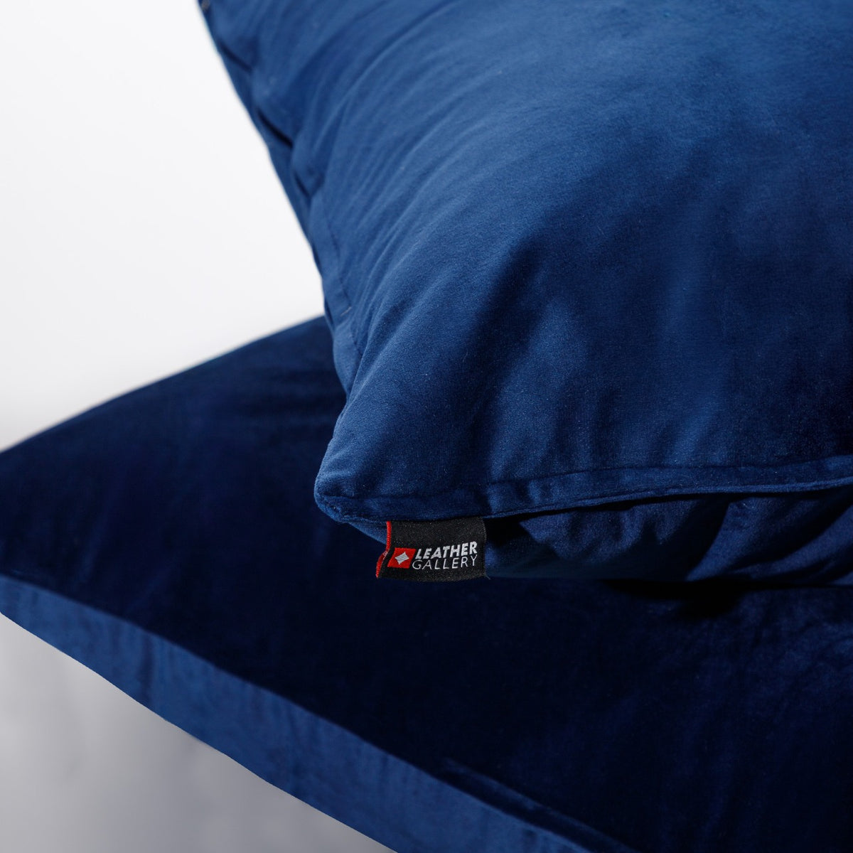 Close-up of the Leather Gallery Fluxx Navy Blue Cushion 59cm x 59cm, showing the soft velvet texture and branded Leather Gallery tag.