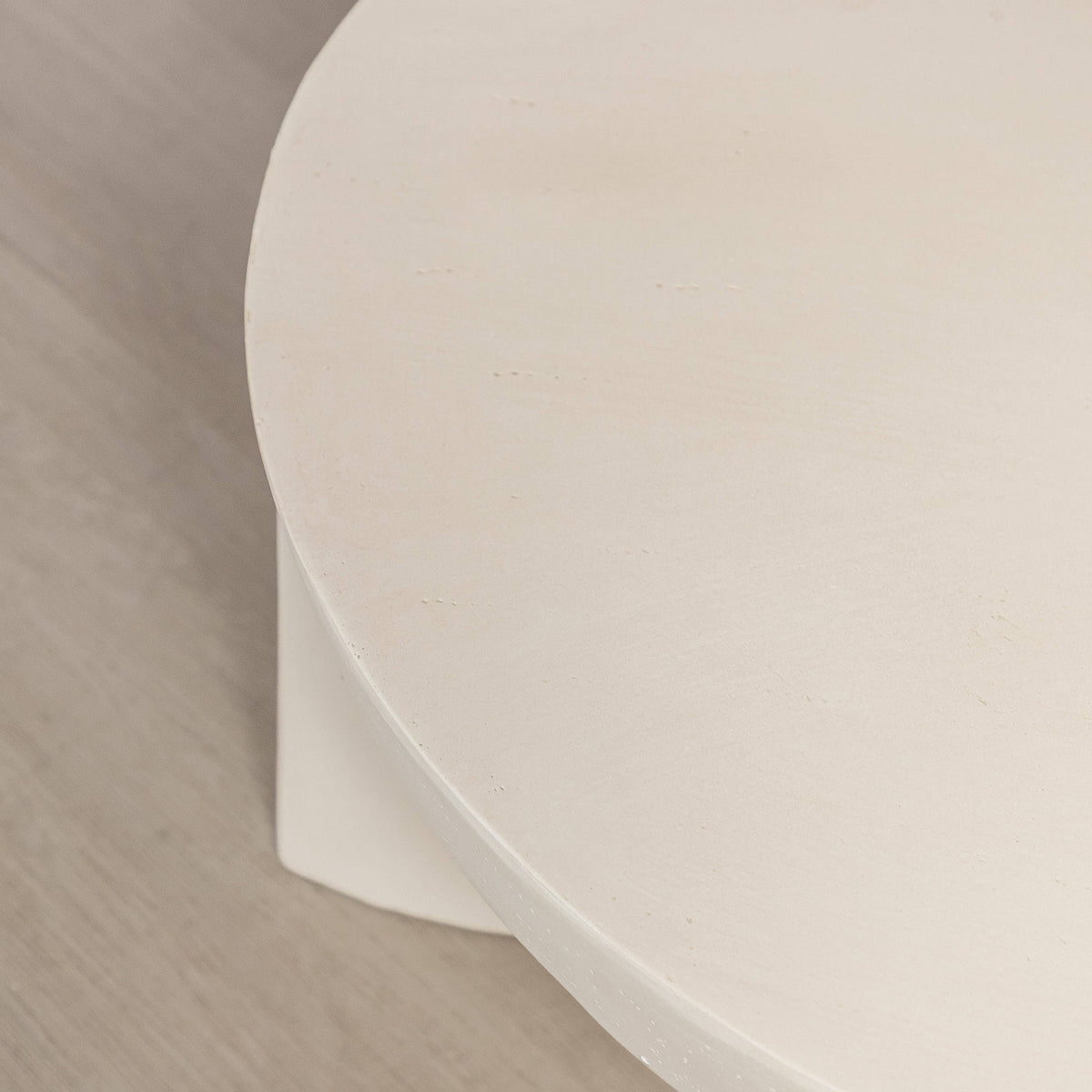 Gallery Everyday Lille Coffee Table in Pale Parchment, featuring a round concrete top and sculptural pedestal base in a bright modern living room.