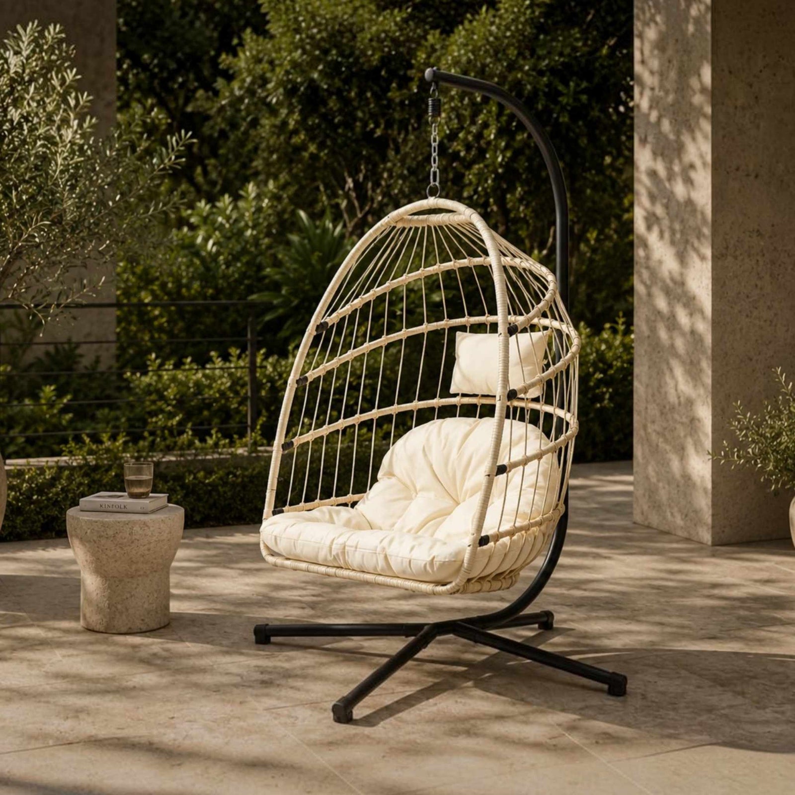 Madison Hanging Chair in beige, shown in a serene, outdoor patio space. | Outdoor chairs, hanging chair, patio furniture, patio chairs