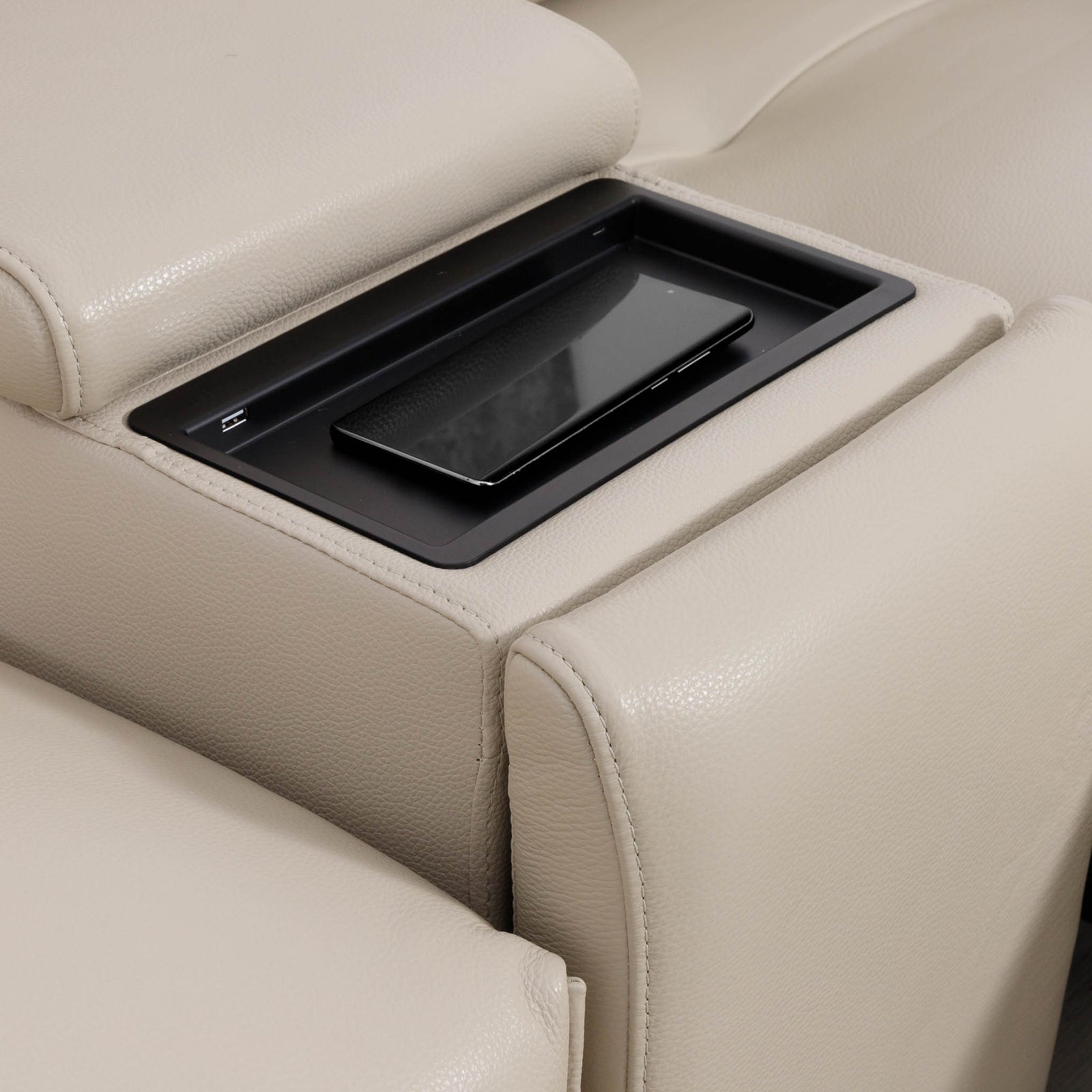 Close-up of the Leather Gallery Marbella 5 Seater Leather L Shape Couch in Cream Beige, showing the armrest and black tray insert with smartphone holder.