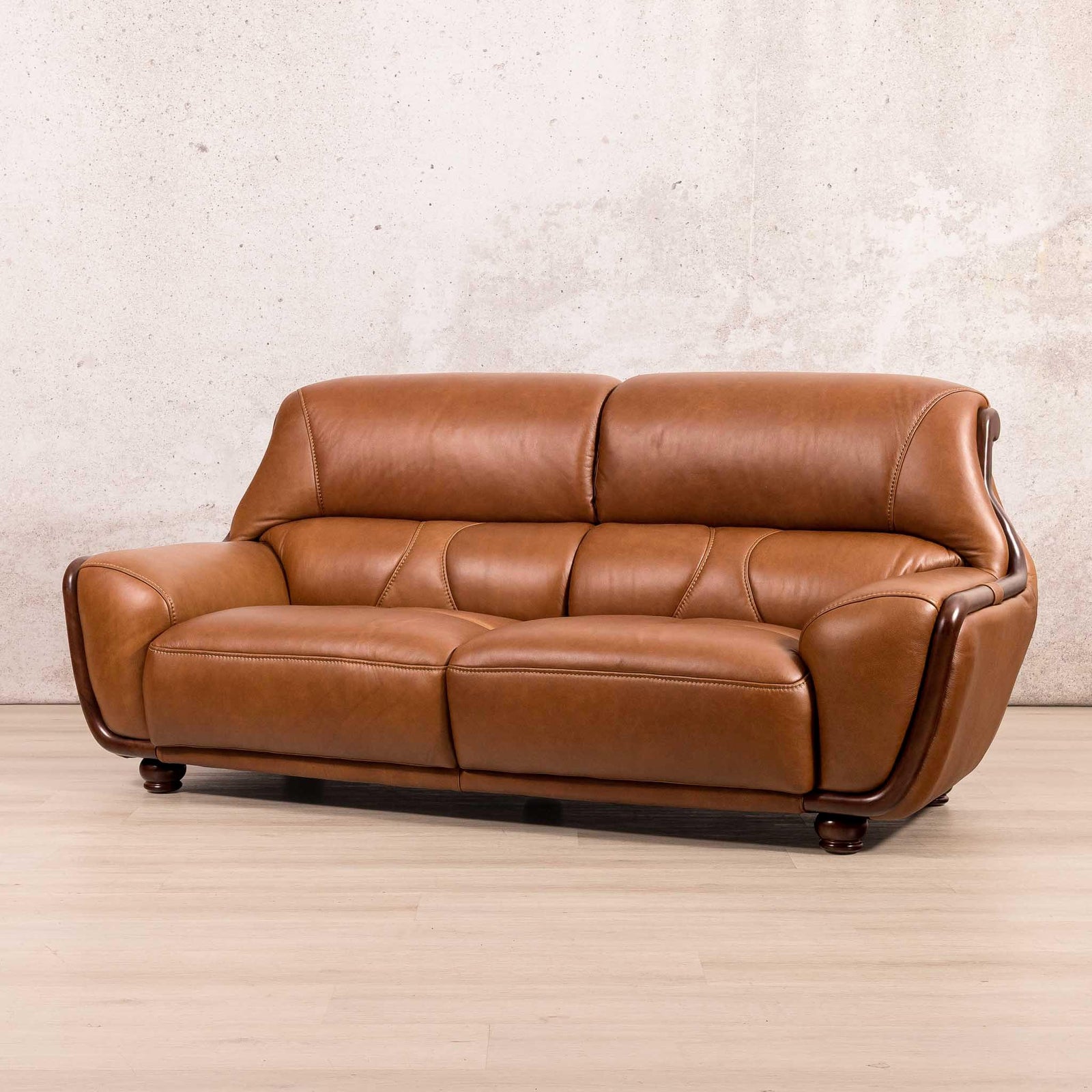Leather Gallery Zuri 3 Seater Leather Couch in Czar Pecan, featuring curved arms and dark wooden legs.