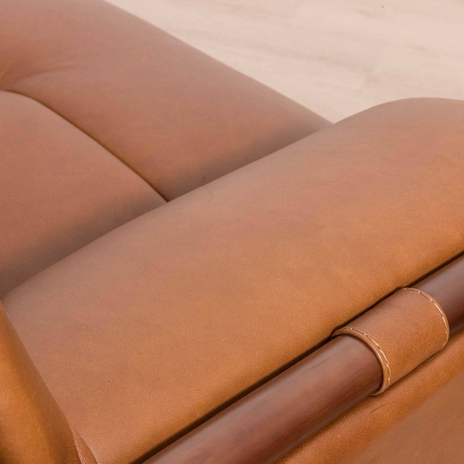 Close-up of the Leather Gallery Zuri 3 Seater Leather Couch in Czar Pecan, showing the dark wood armrest, leather texture, and stitching detail.