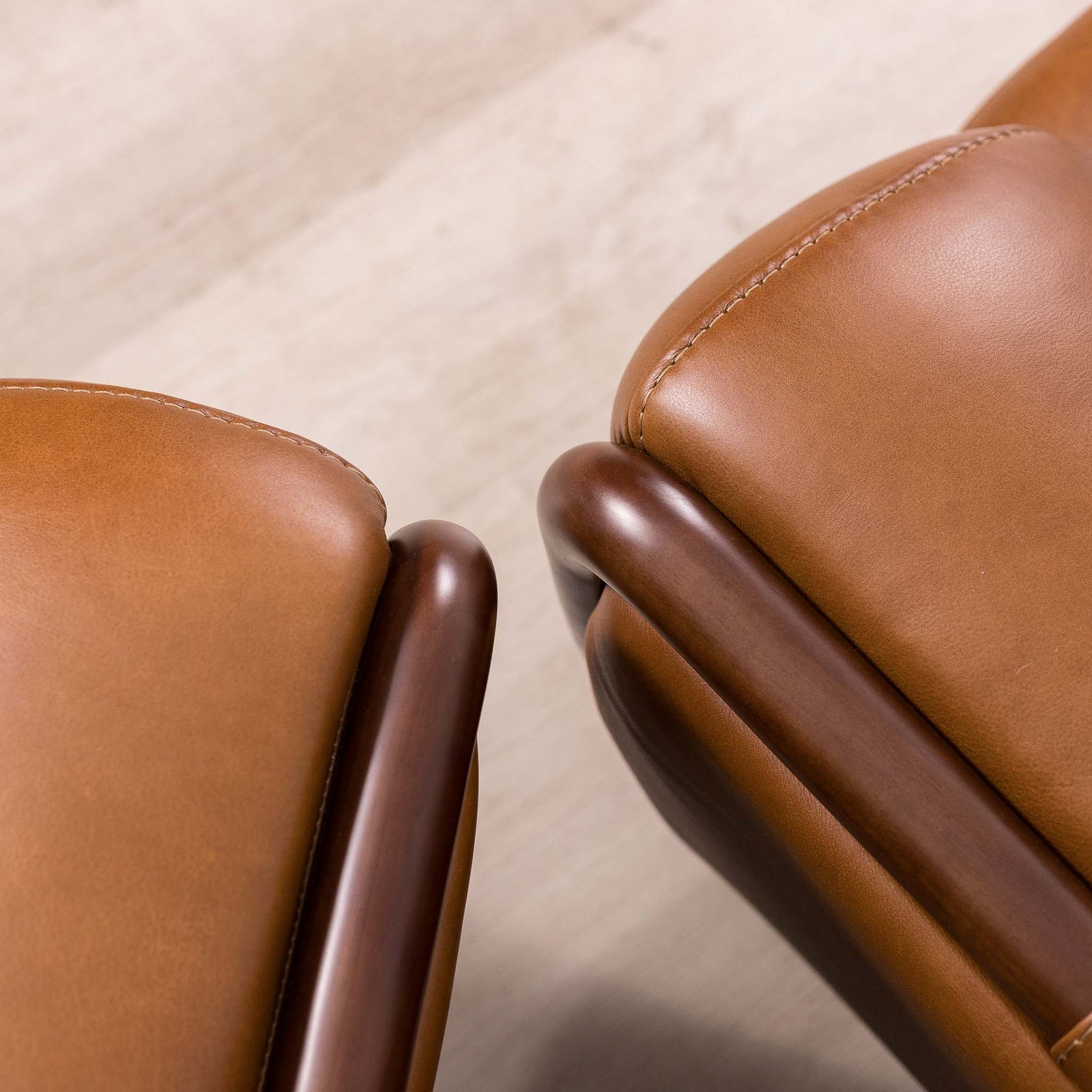 Close-up of the Leather Gallery Zuri 3+2+1 Leather Couch Suite in Czar Pecan, showing tan leather upholstery and dark wooden armrests.