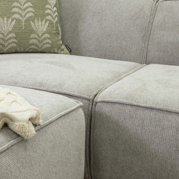 Leather Gallery Austin Fabric Sofa Chaise Sectional in Bordeaux Grey, styled with a patterned green cushion and white throw.