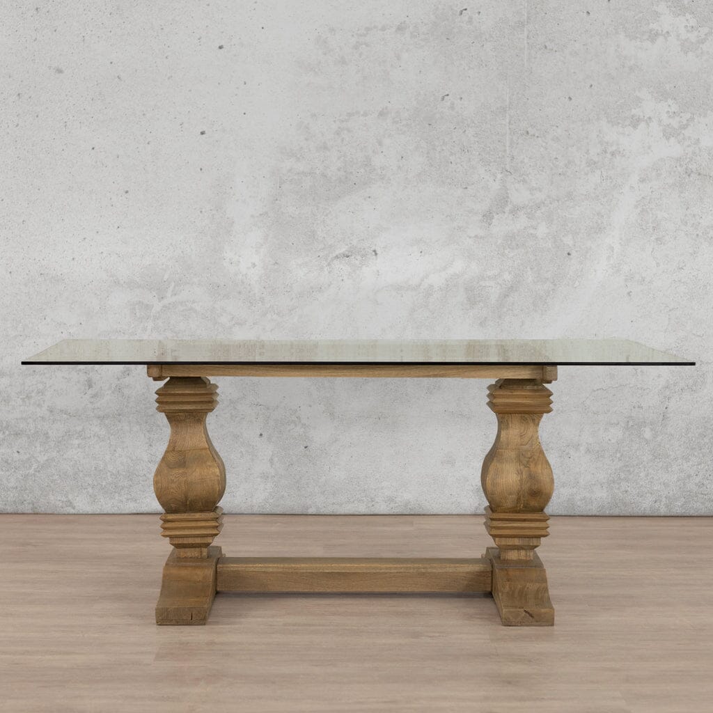 Front view of the Belmont Glass Top Dining Table – 2.4m / 8-10 Seater, designed with a sleek glass top and wooden base in Antique Natural Oak. Leather Gallery