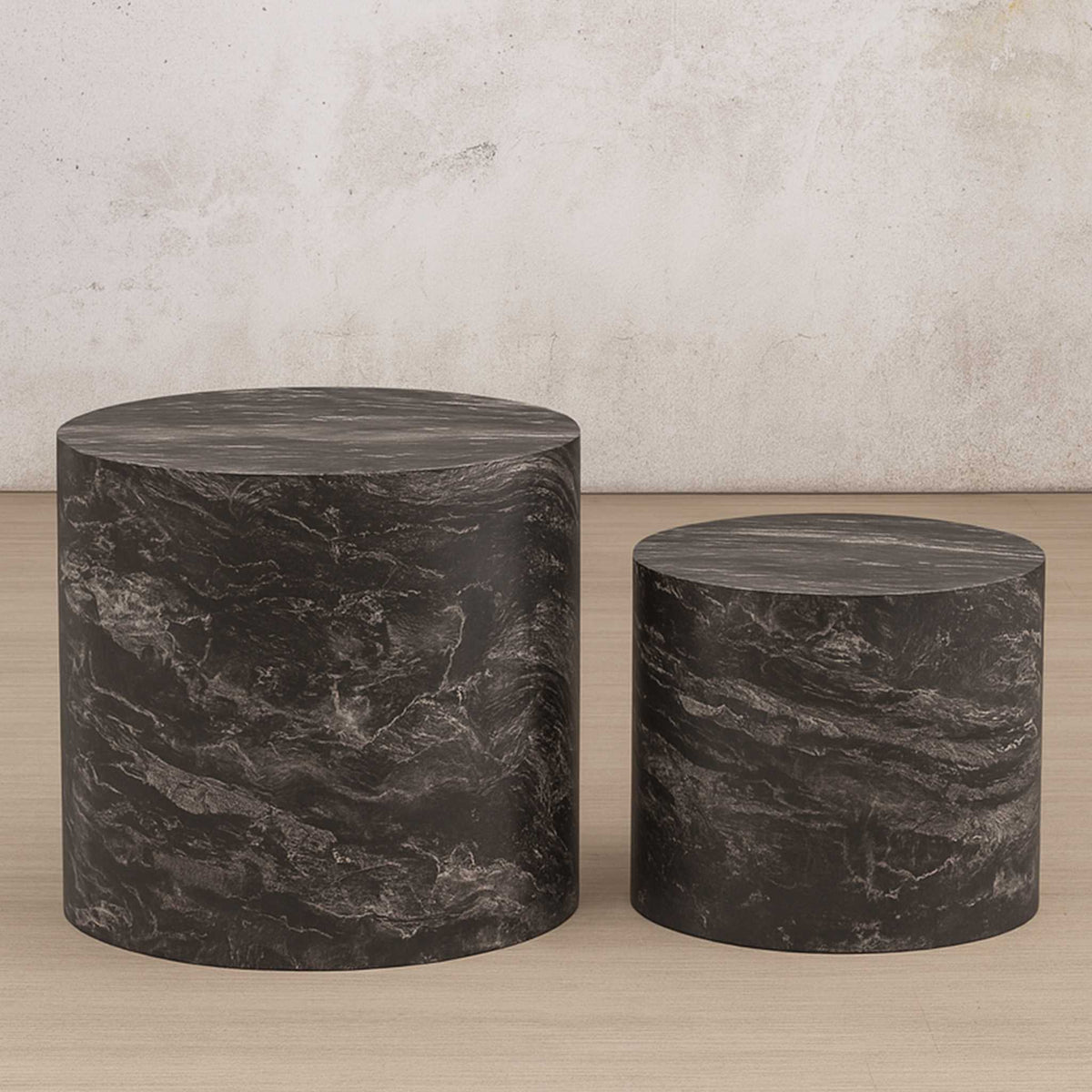 Gallery Everyday Callaway Coffee Table Set of 2, showing one cylindrical marble-look table being held in a living room.