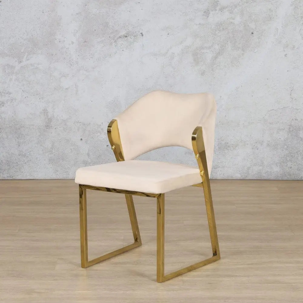 Luxurious gold dining chair with sleek legs and neutral-toned upholstery, perfect for modern statement interiors.
