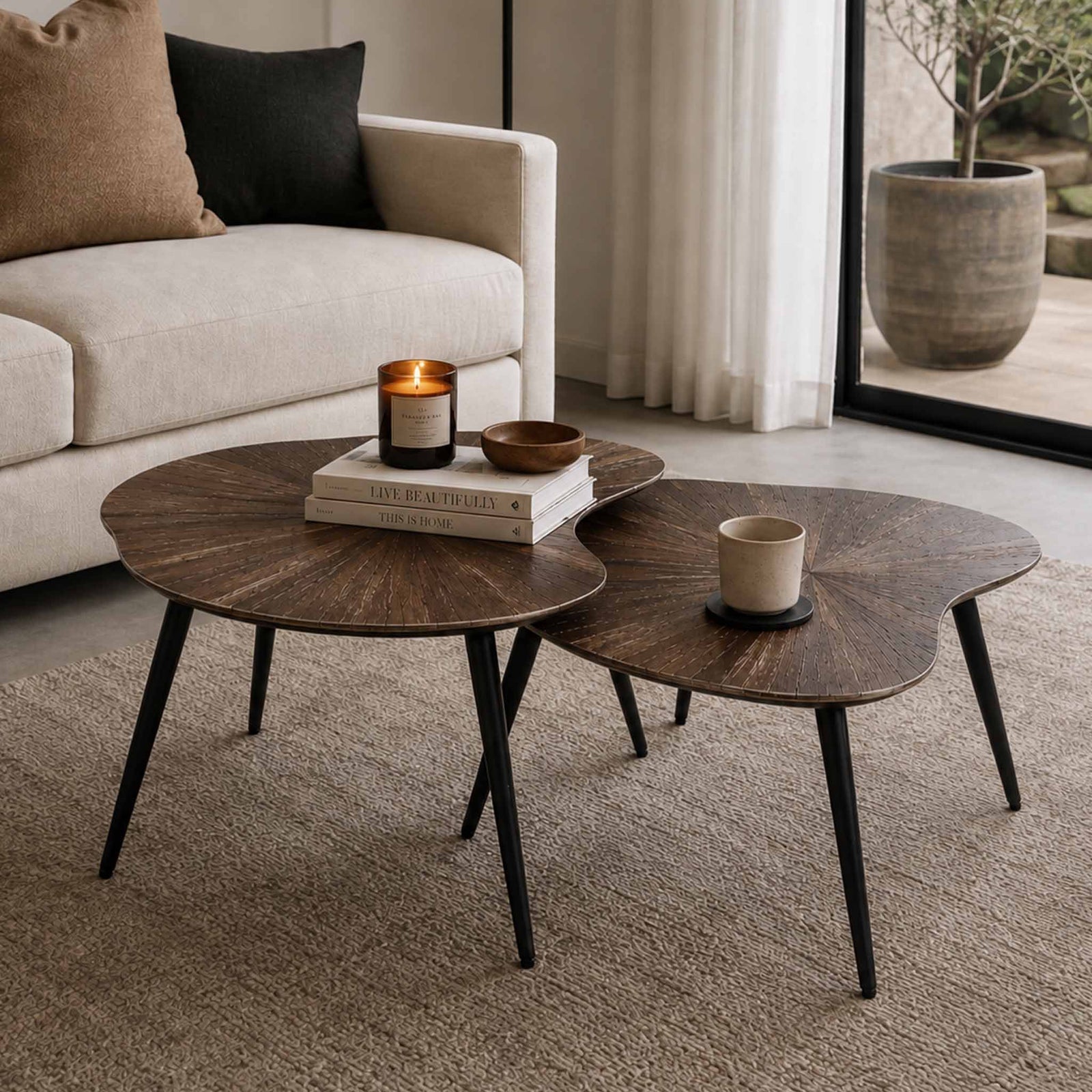 Gallery Everyday Eden Nesting Coffee Tables Set of 2, featuring organic-shaped wooden tops and black metal legs in a modern living room.
