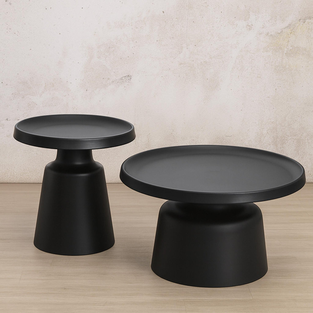 Gallery Everyday Minerva Coffee Table - Black Set of 2, featuring two minimalist black pedestal tables on a wooden floor.