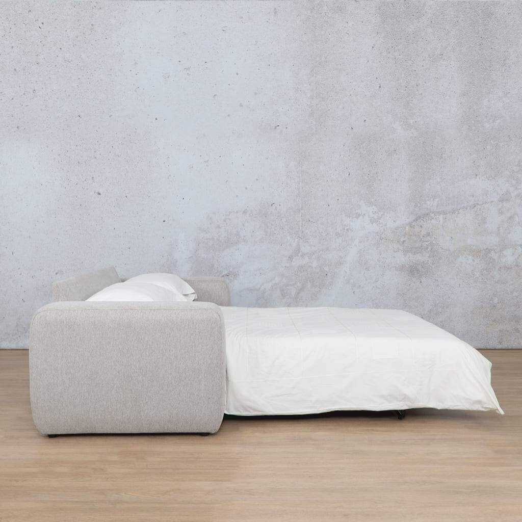 Side view of Leather Gallery’s Stanford fabric sleeper couch arranged as a made-up bed for guests, demonstrating its functionality as both a chic sleeper couch and a comfortable sleeping option. Ideal for spaces requiring a versatile sleeper couch. oyster