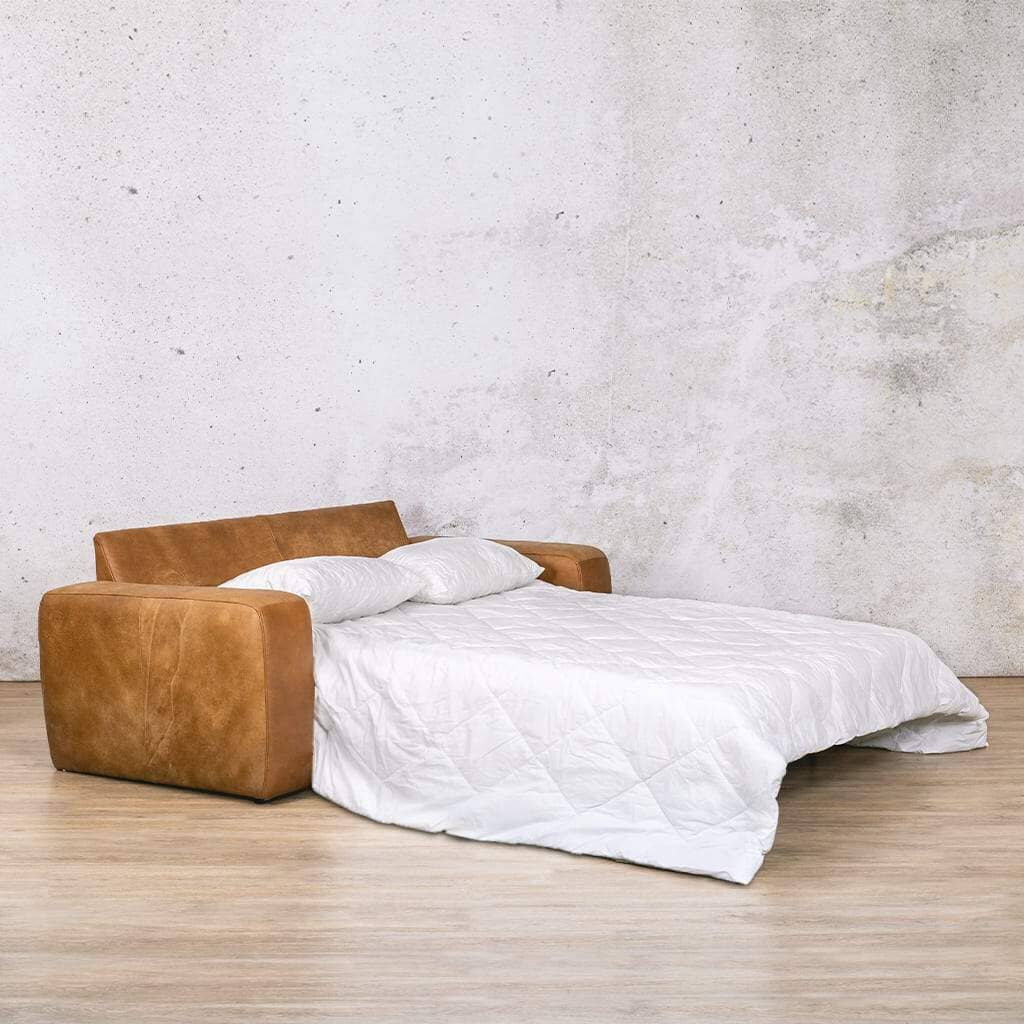 Angled Front View of the Bed Mode Stanford Leather Sleeper Couch | Leather side view of the Stanford leather sleeper couch fully extended into a bed, complete with pillows for added comfort and style, ideal for guest accommodation. Buy your sleeper couch today at Leather Galley. Czar Pecan