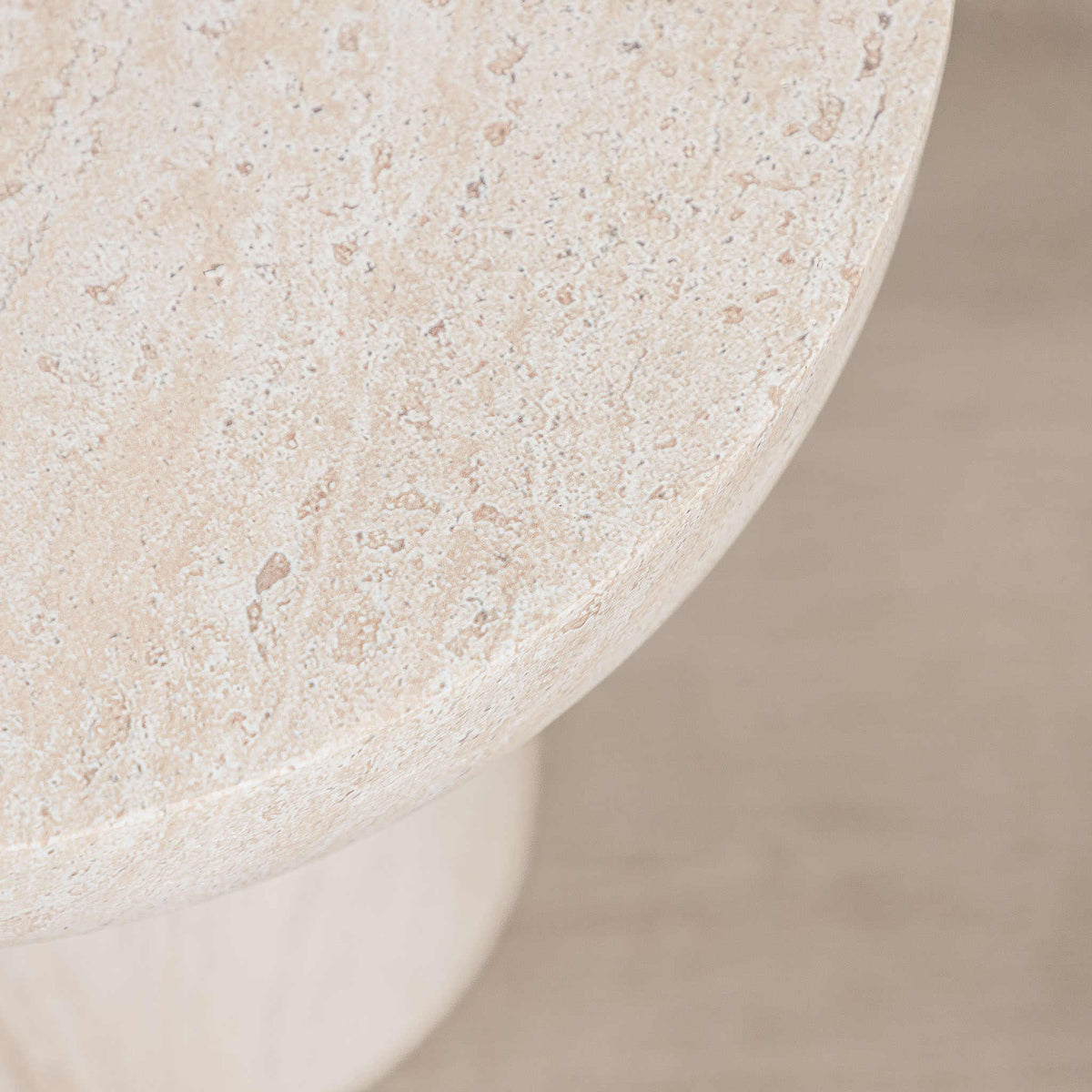 Gallery Everyday Aquila Side Table in Seashell, featuring a round travertine-look top and pedestal base in a warm beige finish.