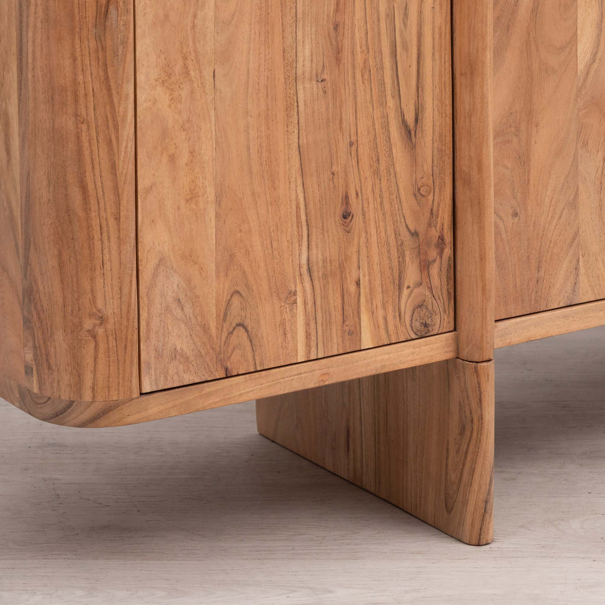 Close-up of the Leather Gallery Baltic Sideboard in Acacia wood, showing curved panel doors and a block-style pedestal leg.