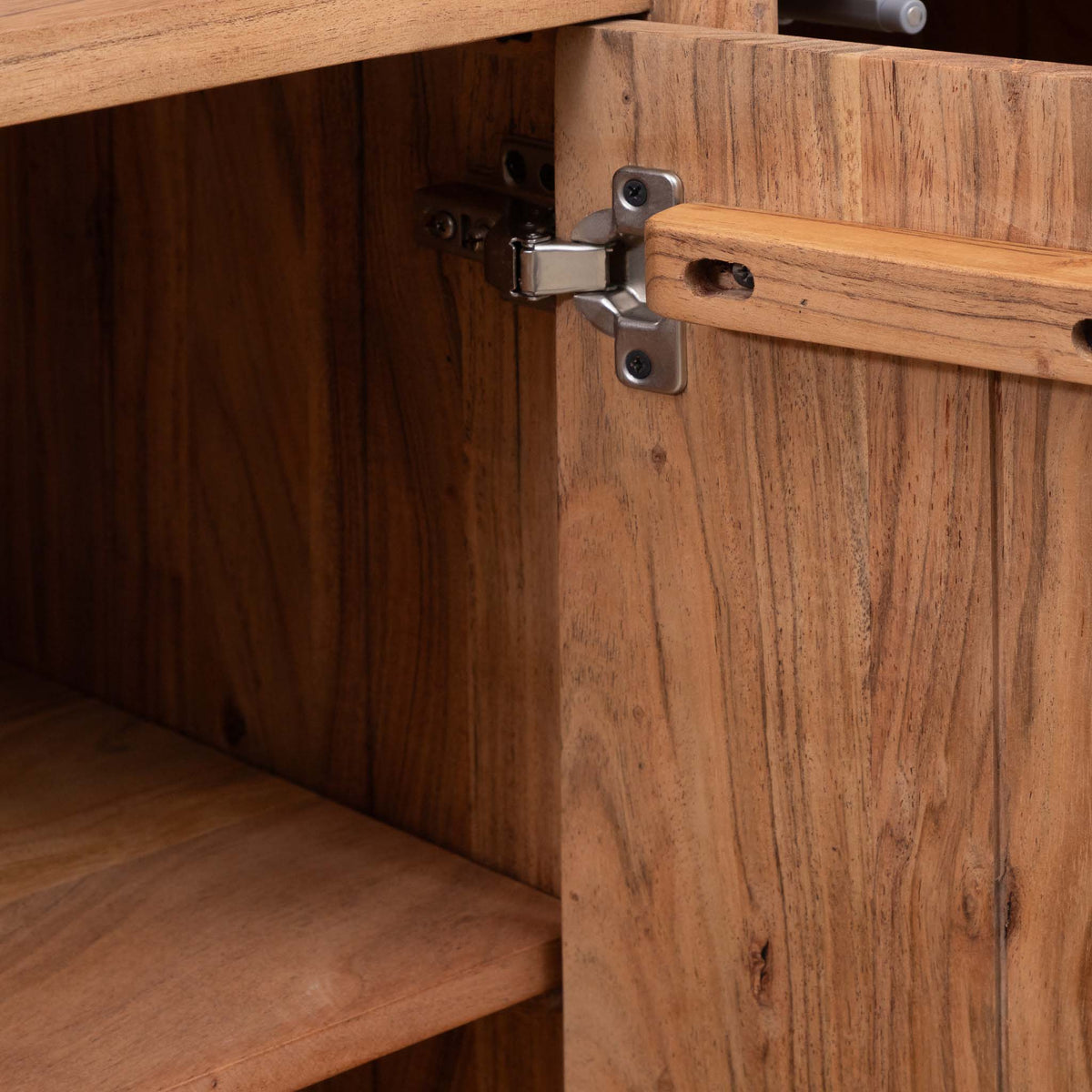 Close-up of the Leather Gallery Baltic Sideboard in Acacia wood, showing the silver metal hinge, warm wood grain, and internal shelf construction.