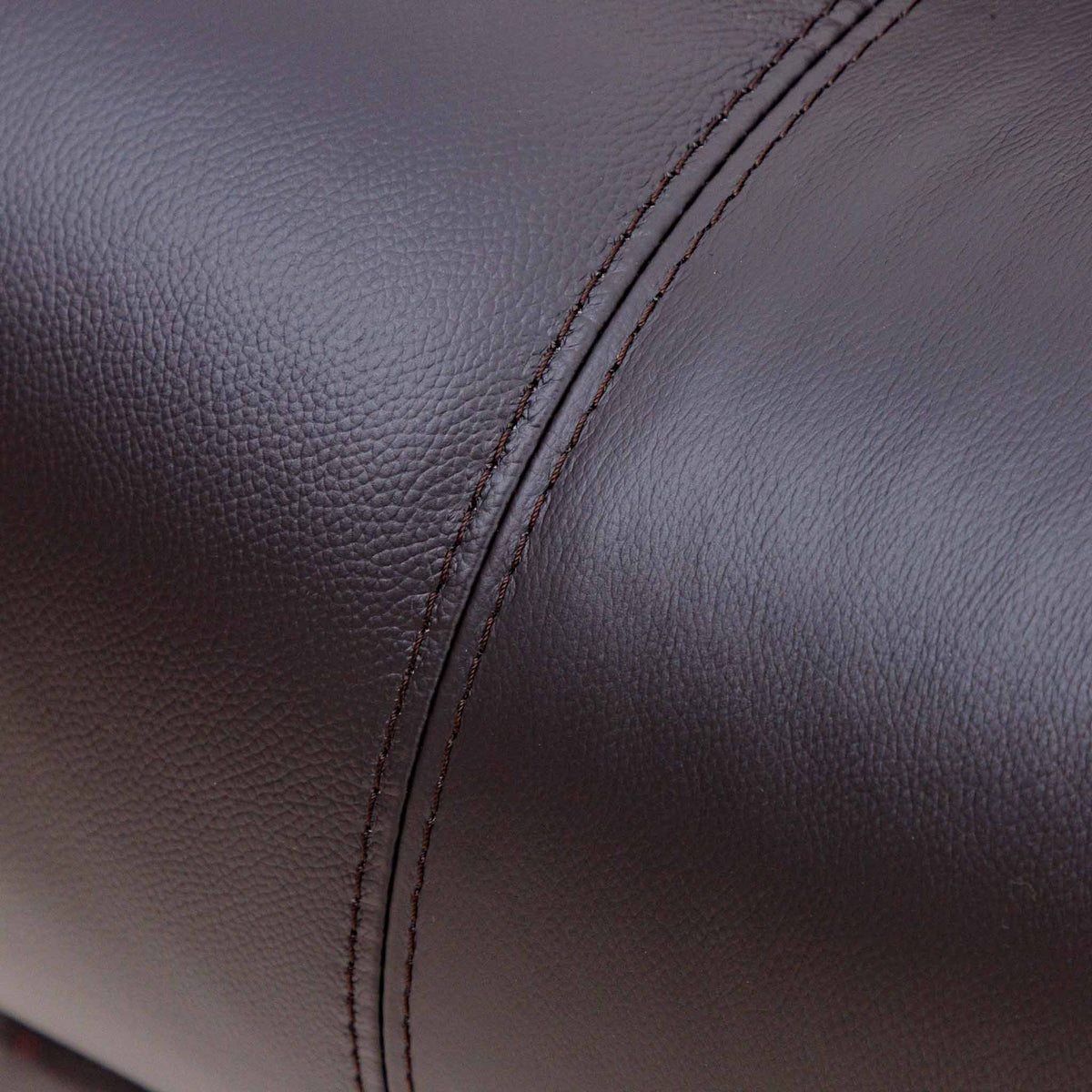 Close-up of the Leather Gallery Cairo 2 Seater Leather Recliner in Choc, showing pebbled leather upholstery, a curved seam, and double stitching.