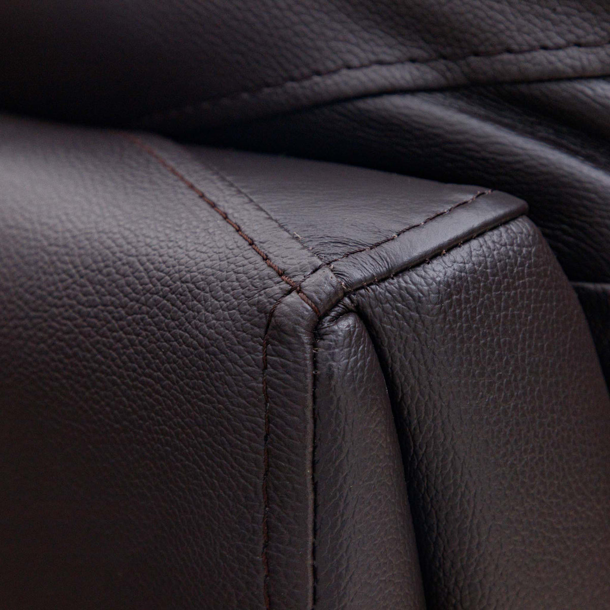 Close-up of the Leather Gallery Cairo 1 Seater Leather Recliner in Choc, showing the pebbled leather armrest, precise stitching, and corner seam.