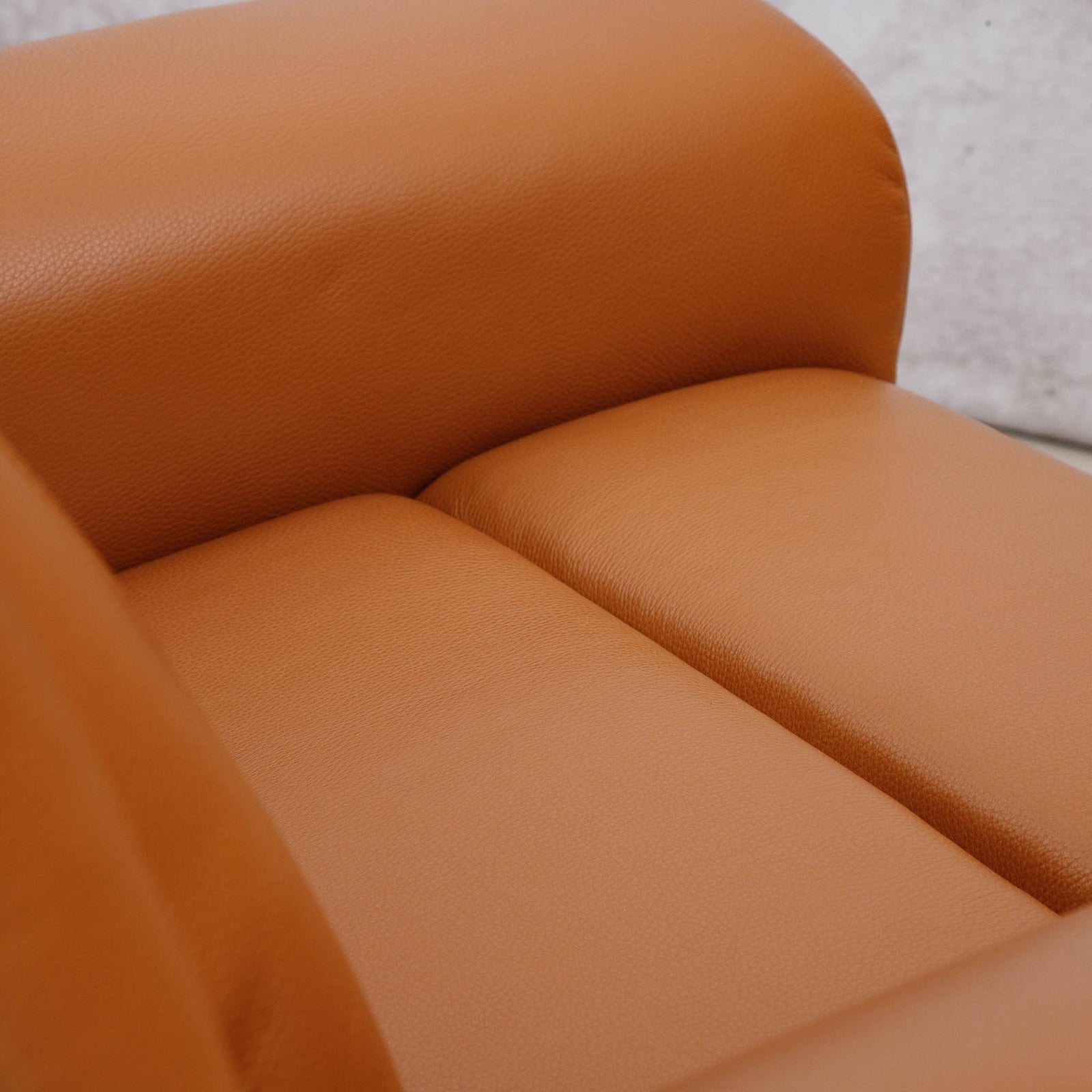 Close-up of the Leather Gallery Carter 1 Seater Leather Recliner Chair in Tan, showing the textured leather seat cushion and rounded armrest.