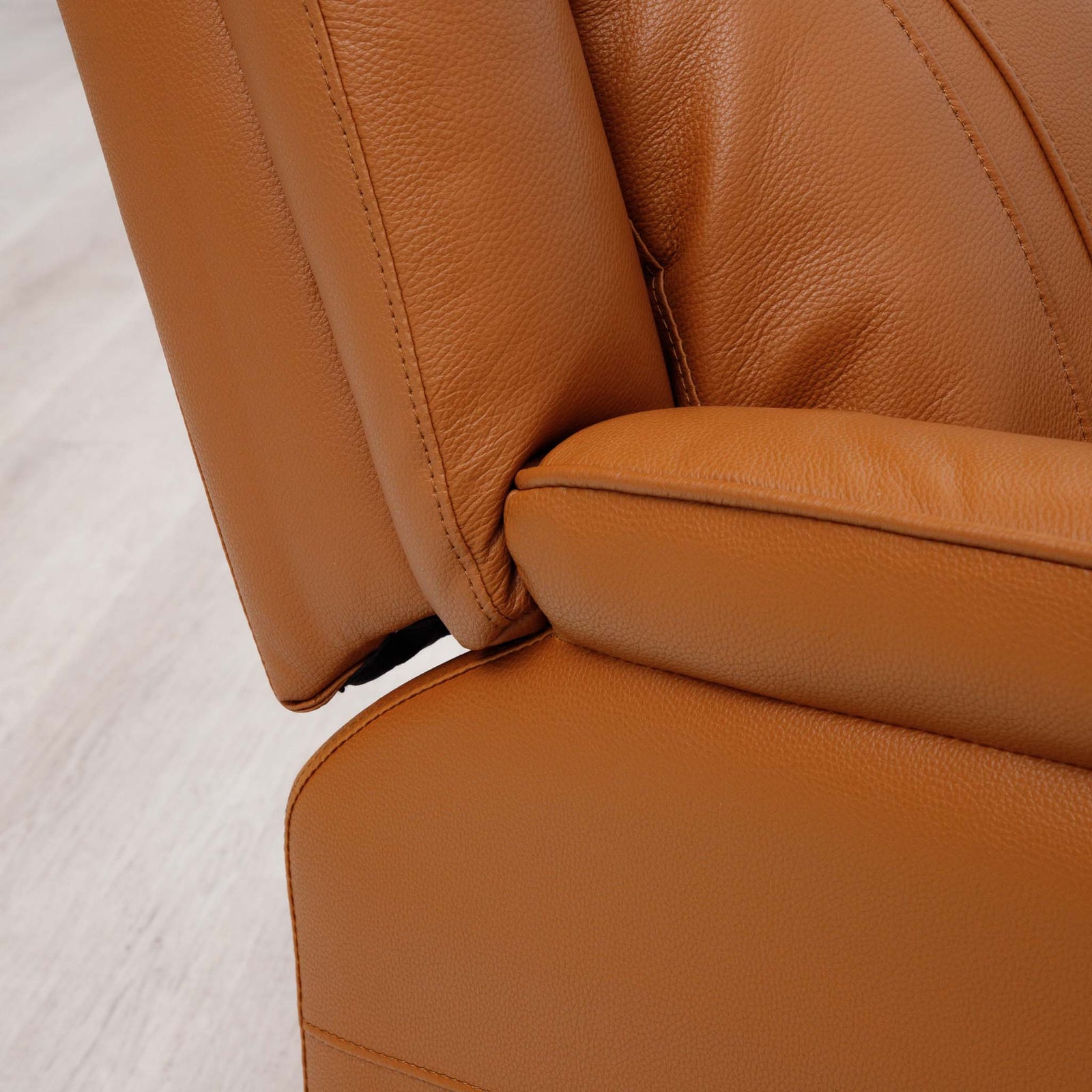 Close-up of the Leather Gallery Carter 1 Seater Leather Recliner Chair in Tan, showing textured leather, visible stitching, and the seat-back joint.