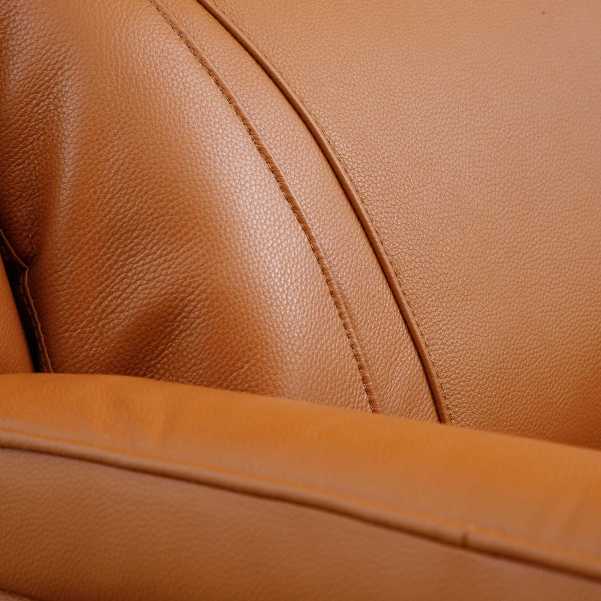 Close-up of the Leather Gallery Carter 1 Seater Leather Recliner Chair in Tan, showing pebbled leather texture, stitched seams, and the curved armrest.