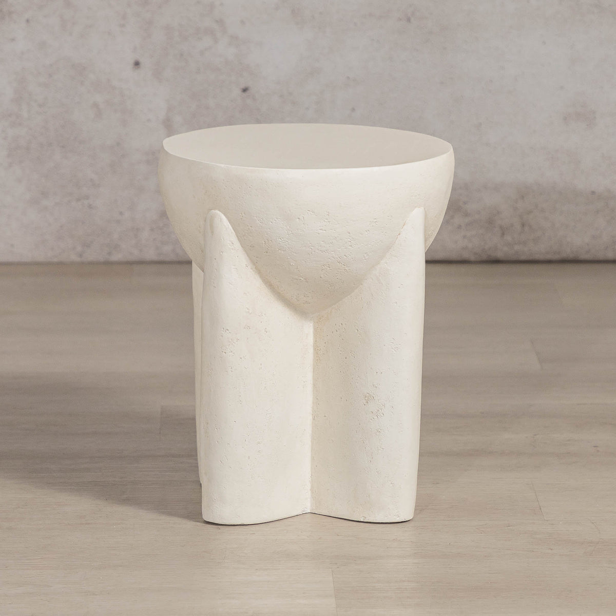Gallery Everyday Castello Side Table, featuring a sculptural off-white concrete design styled beside a beige sofa.