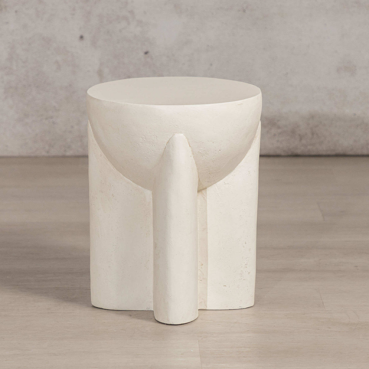 Gallery Everyday Castello Side Table, featuring a sculptural off-white concrete design styled beside a beige sofa.