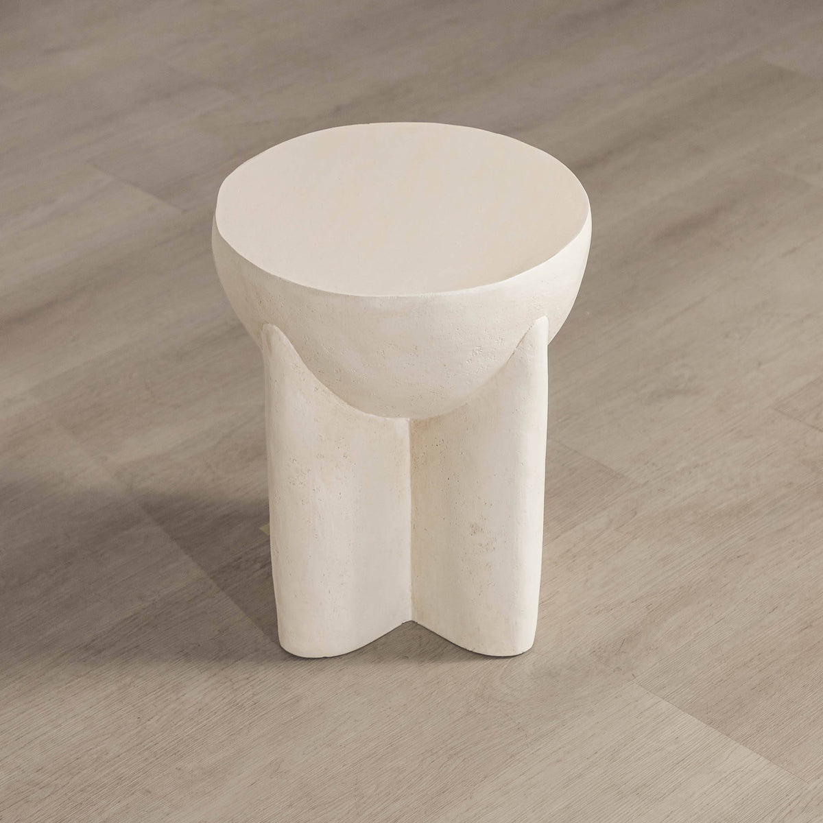 Gallery Everyday Castello Side Table, featuring a sculptural off-white concrete design styled beside a beige sofa.
