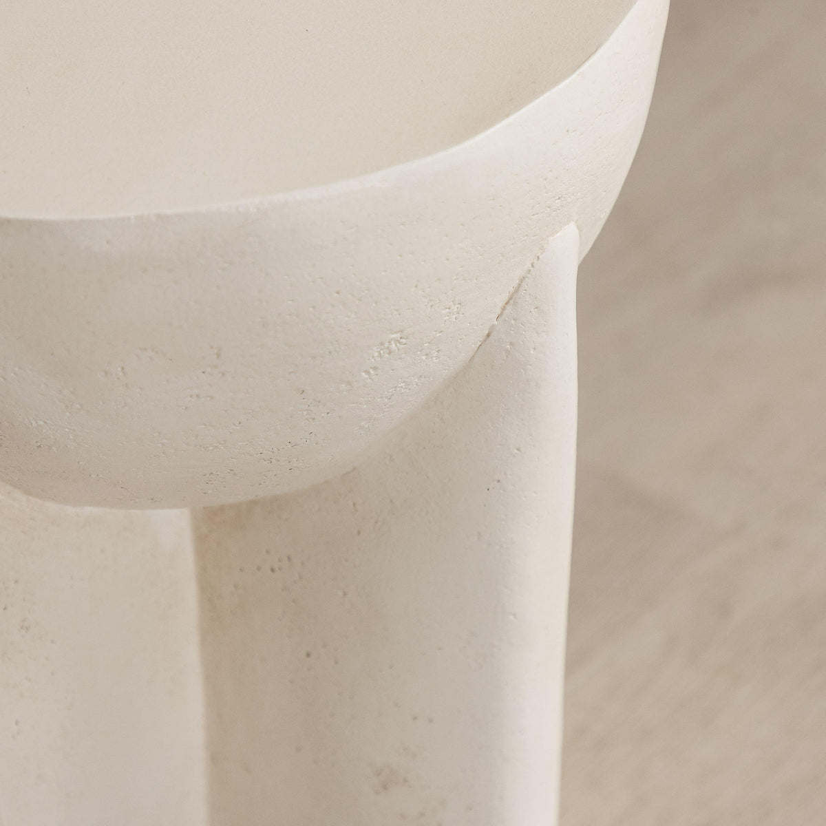 Gallery Everyday Castello Side Table, featuring a sculptural off-white concrete design styled beside a beige sofa.