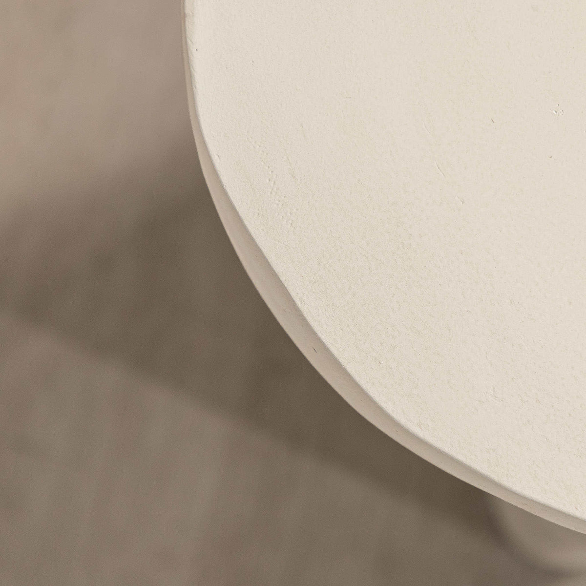 Gallery Everyday Castello Side Table, featuring a sculptural off-white concrete design styled beside a beige sofa.