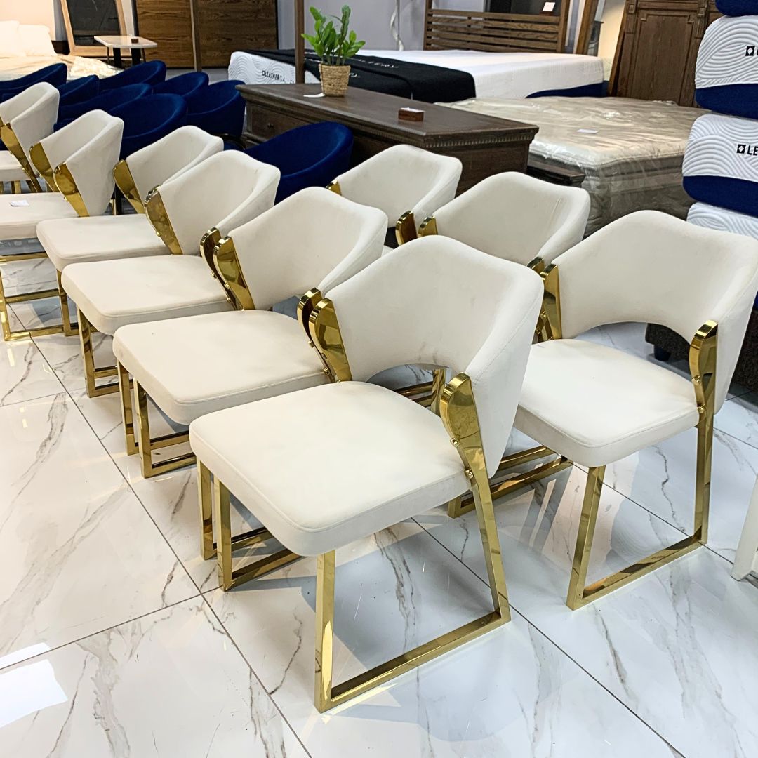 Gold dining chair positioned at the head of a dining table, adding glamour and sophistication to the space. 