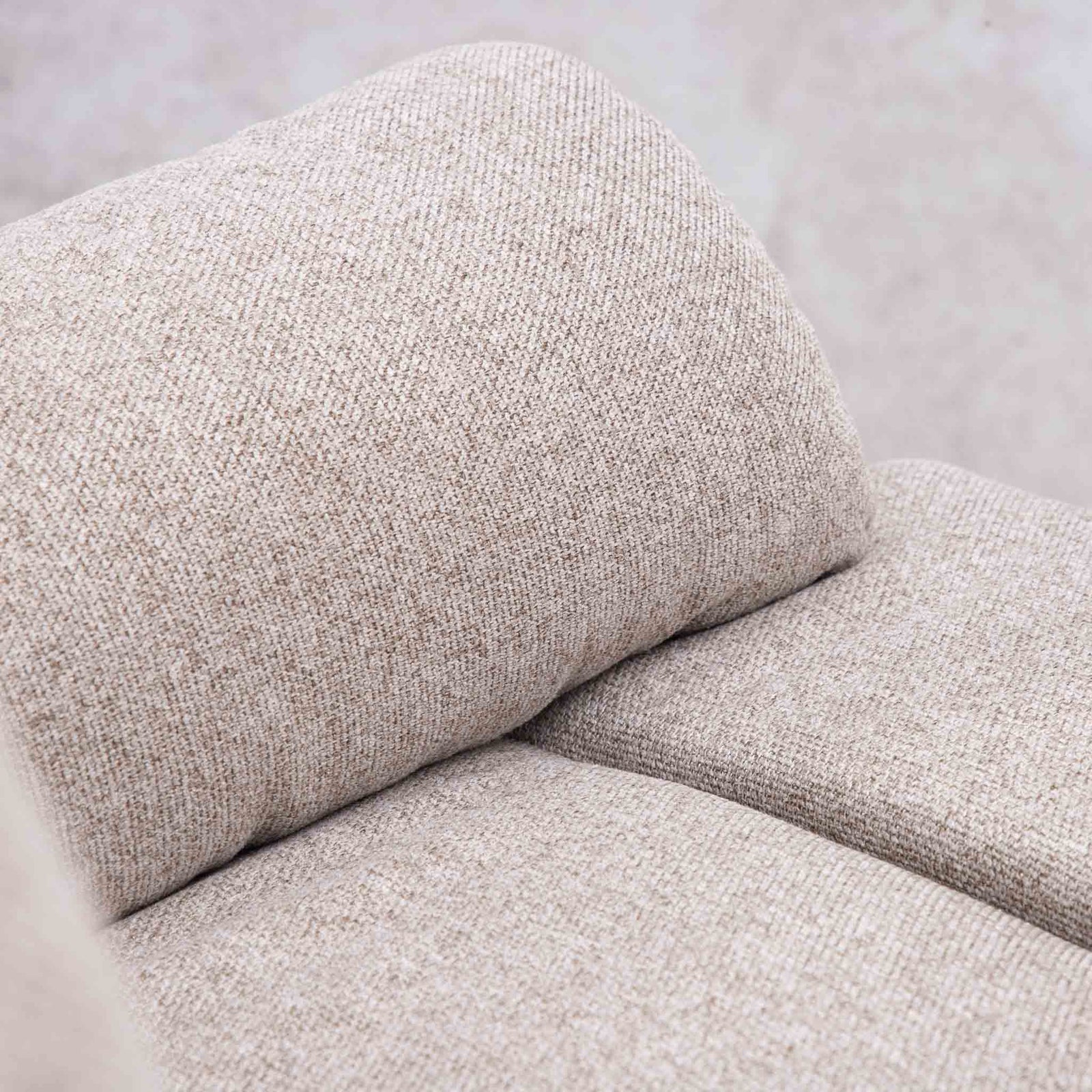 Close-up of the Leather Gallery Dallas Fabric Rocker Recliner Chair in Beige, showing the textured woven fabric cushion and soft curved shape.