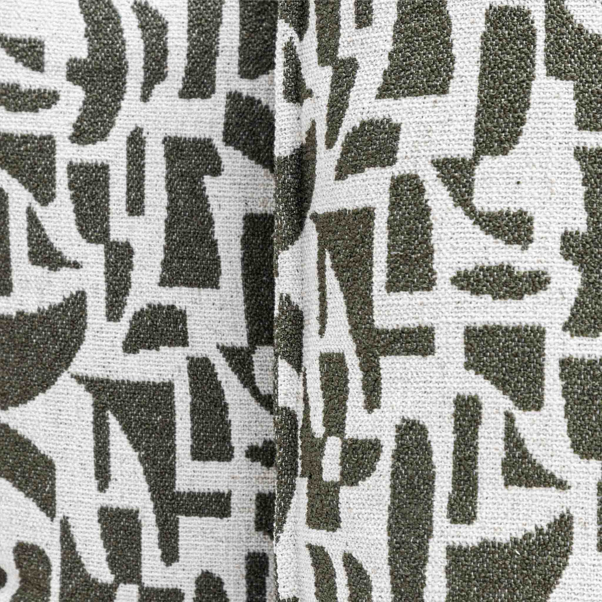 Close-up of the Leather Gallery Krait Cushion in Mediterranean Olive, showing the woven fabric texture and abstract geometric pattern.
