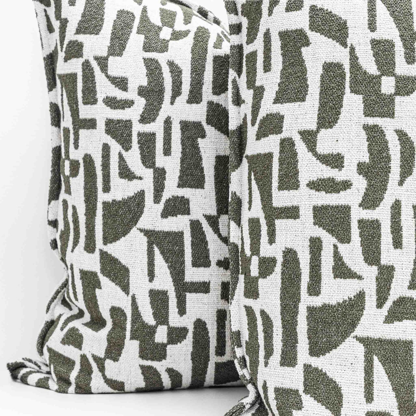Two Leather Gallery Krait Cushions in Mediterranean Olive, featuring an abstract geometric pattern in olive green and off-white.