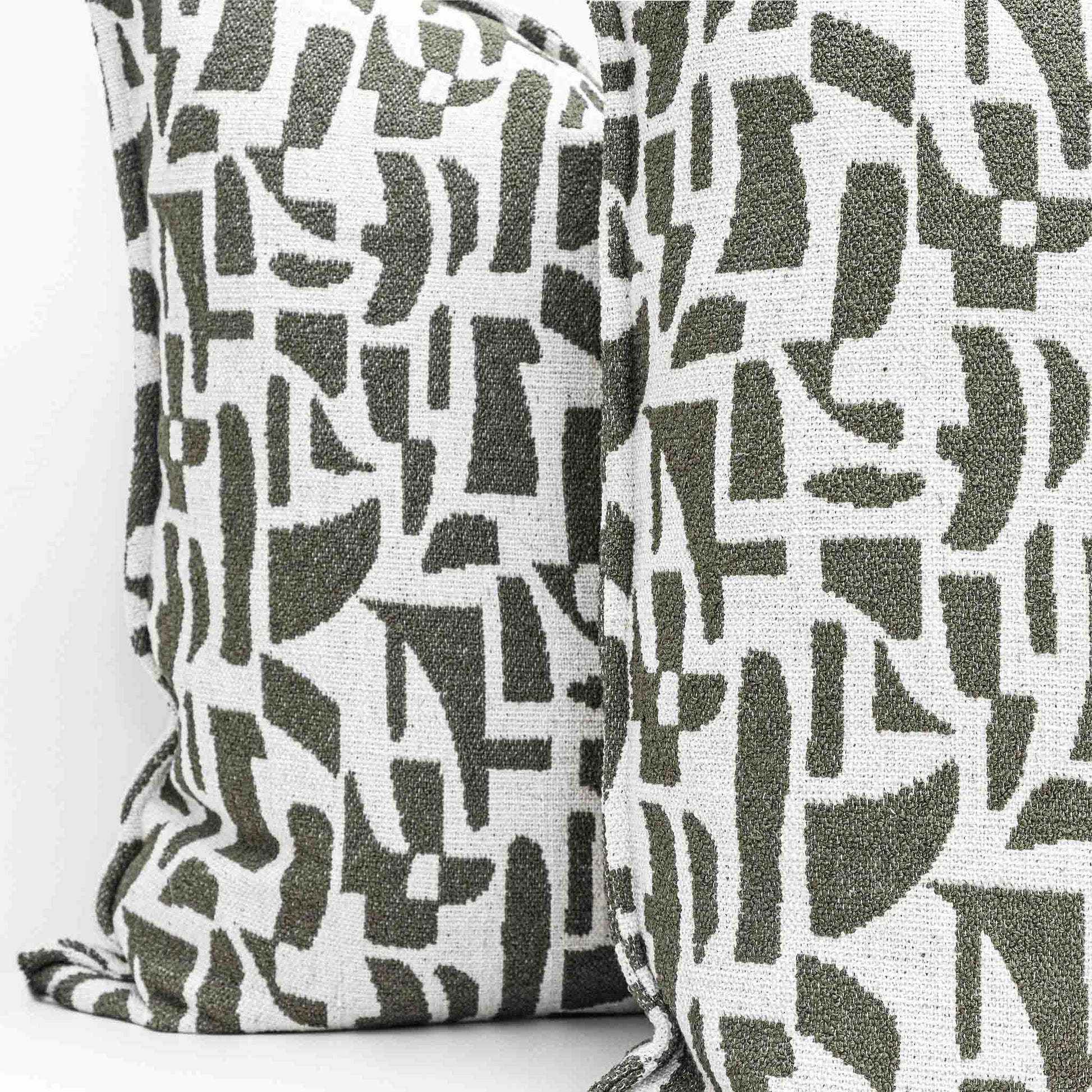 Two Leather Gallery Krait Cushions in Mediterranean Olive, featuring an abstract geometric pattern in olive green and off-white.