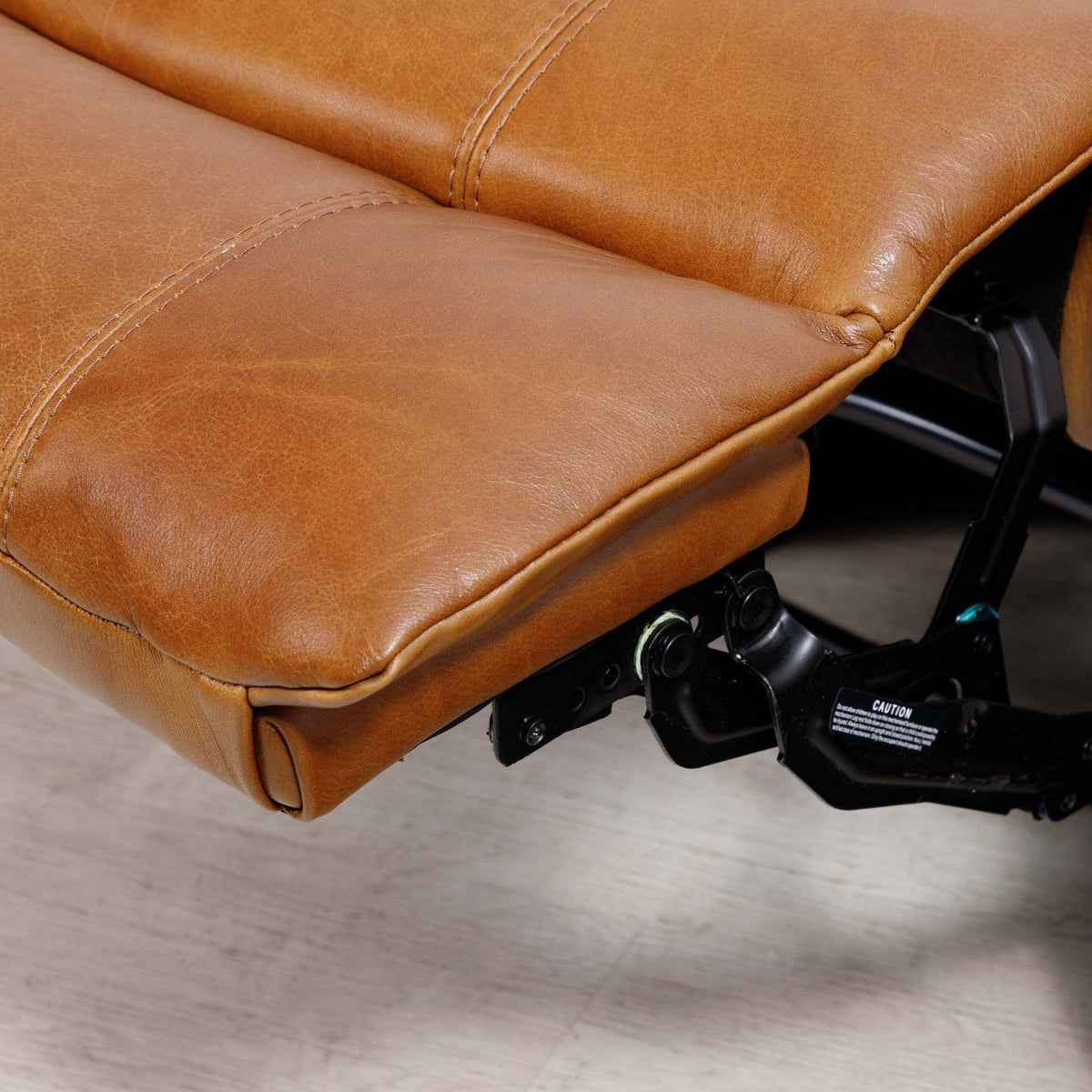 Close-up of the Leather Gallery Kuta 1 Seater Leather Recliner in Czar Pecan, showing the leather cushion and black mechanical support hardware.