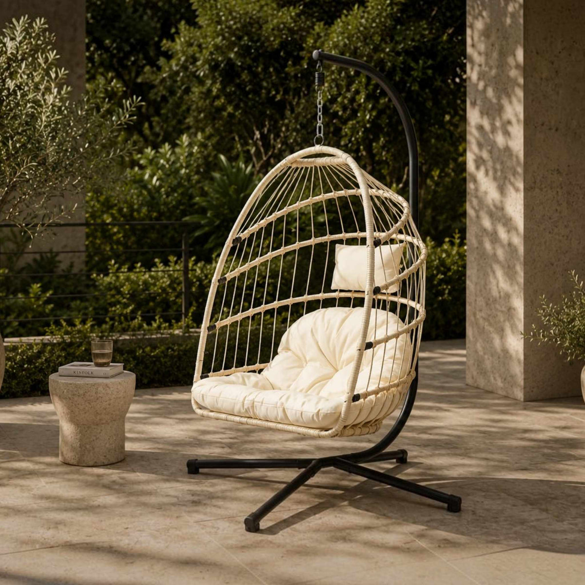 Madison Hanging Chair in beige, shown in a serene, outdoor patio space. | Outdoor chairs, hanging chair, patio furniture, patio chairs 