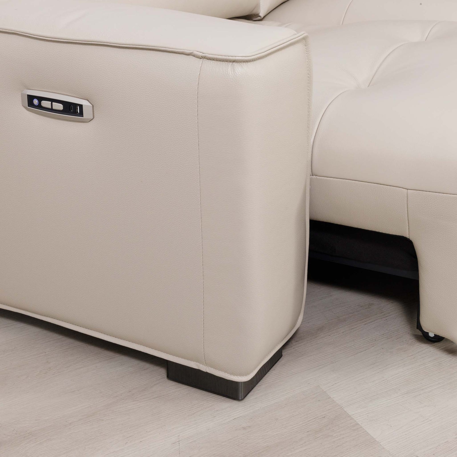 Close-up of the Leather Gallery Marbella 5 Seater Leather L Shape Couch in Cream Beige, showing the side power control and black caster wheels.