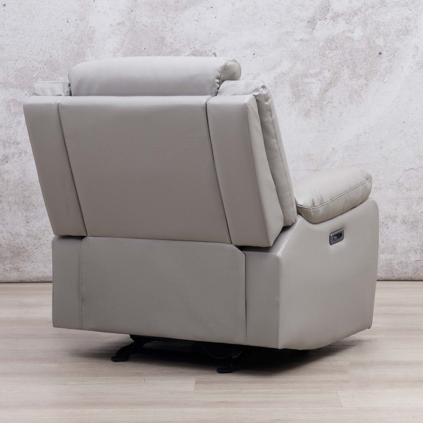 Rear view of the Leather Gallery Marino 1 Seater Leather Recliner in Luxe Grey, with upholstered detailing against a textured wall and light wood floor.