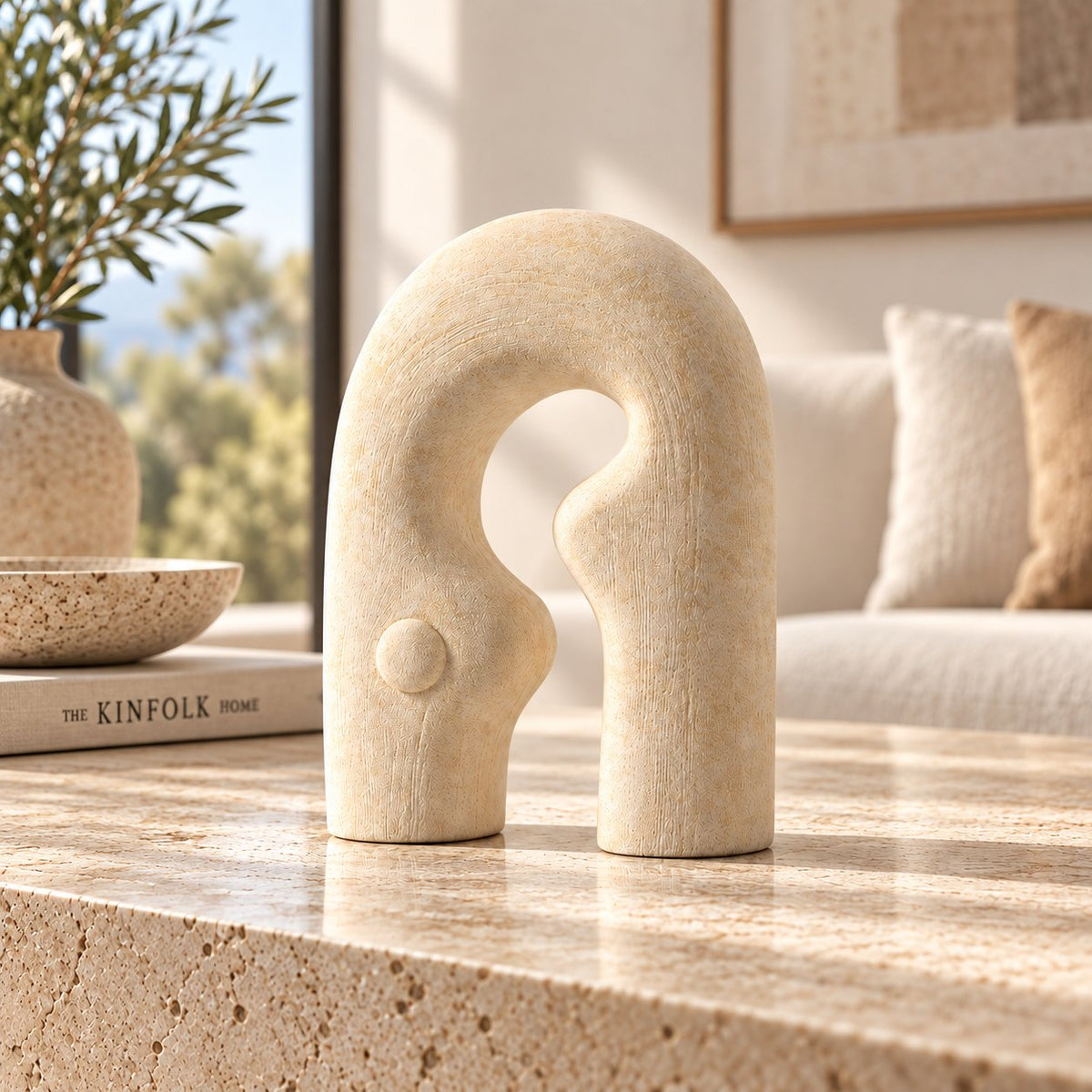 Gallery Everyday Matera Arch Ornament, featuring a textured cream abstract design on a marble coffee table.
