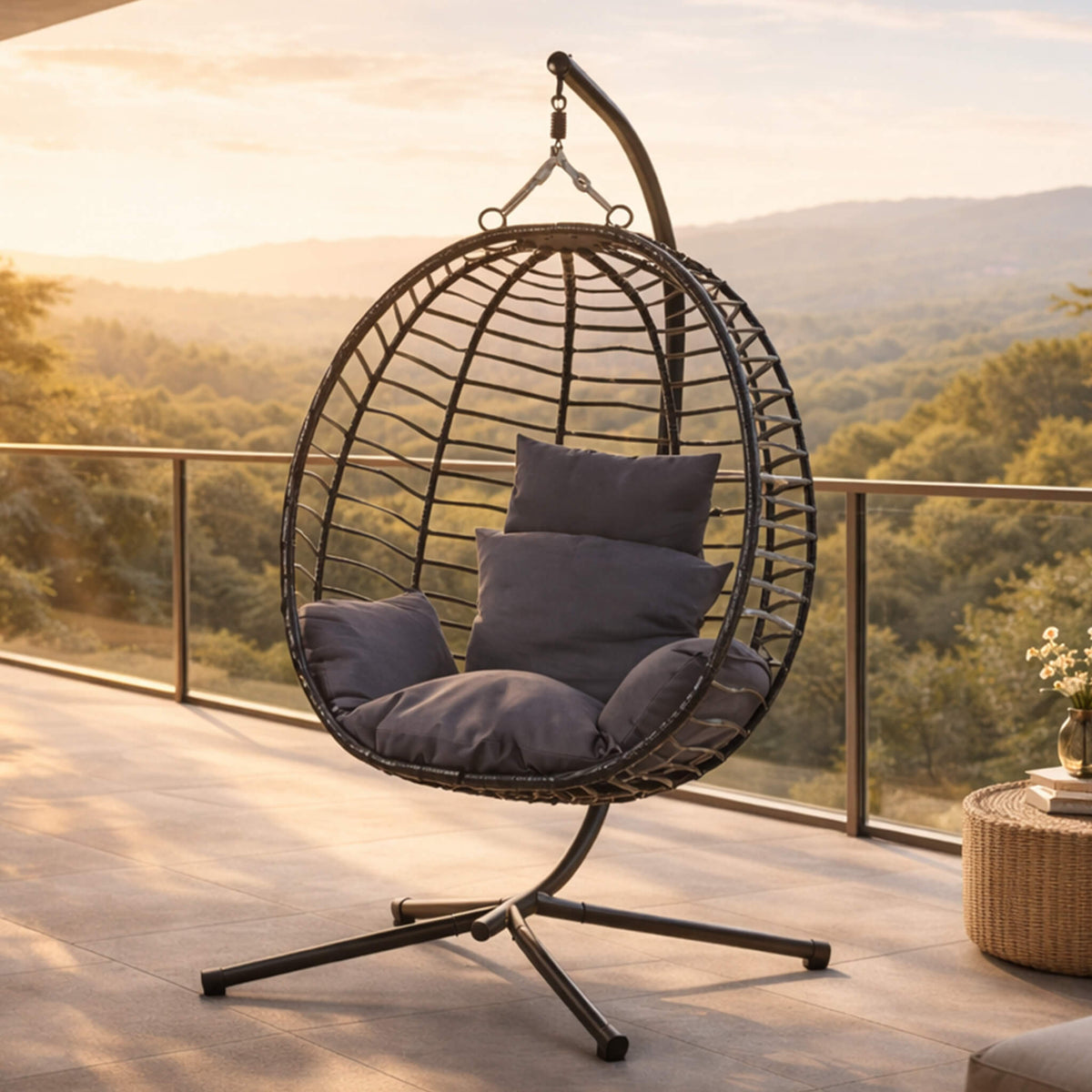 Quinn Hanging Chair in a dark grey hue, shown in a scenic, spacious patio area. | Hanging Chairs, outdoor chairs for sale, egg chair, patio chairs 