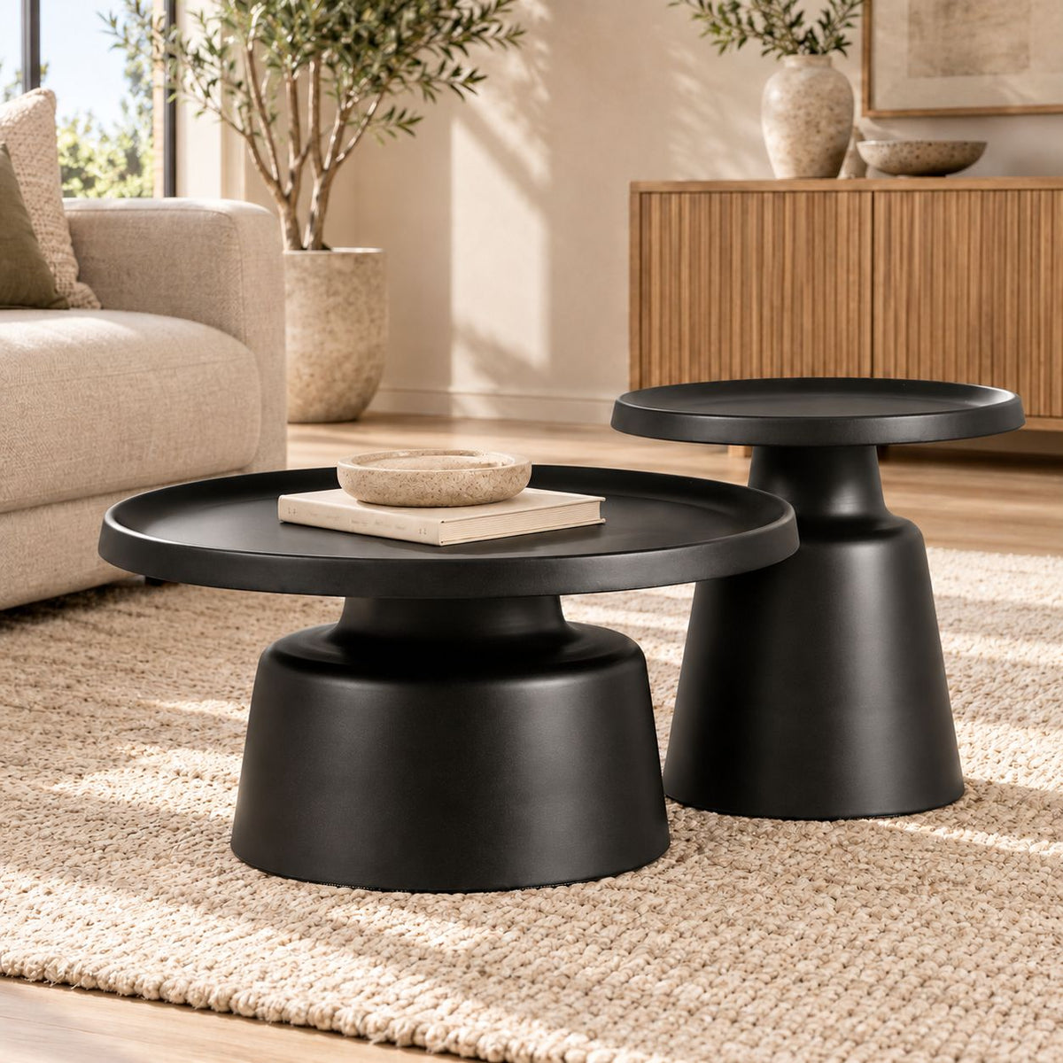 Gallery Everyday Minerva Coffee Table - Black Set of 2, featuring round pedestal tables styled with books, a candle, and a ceramic vase.