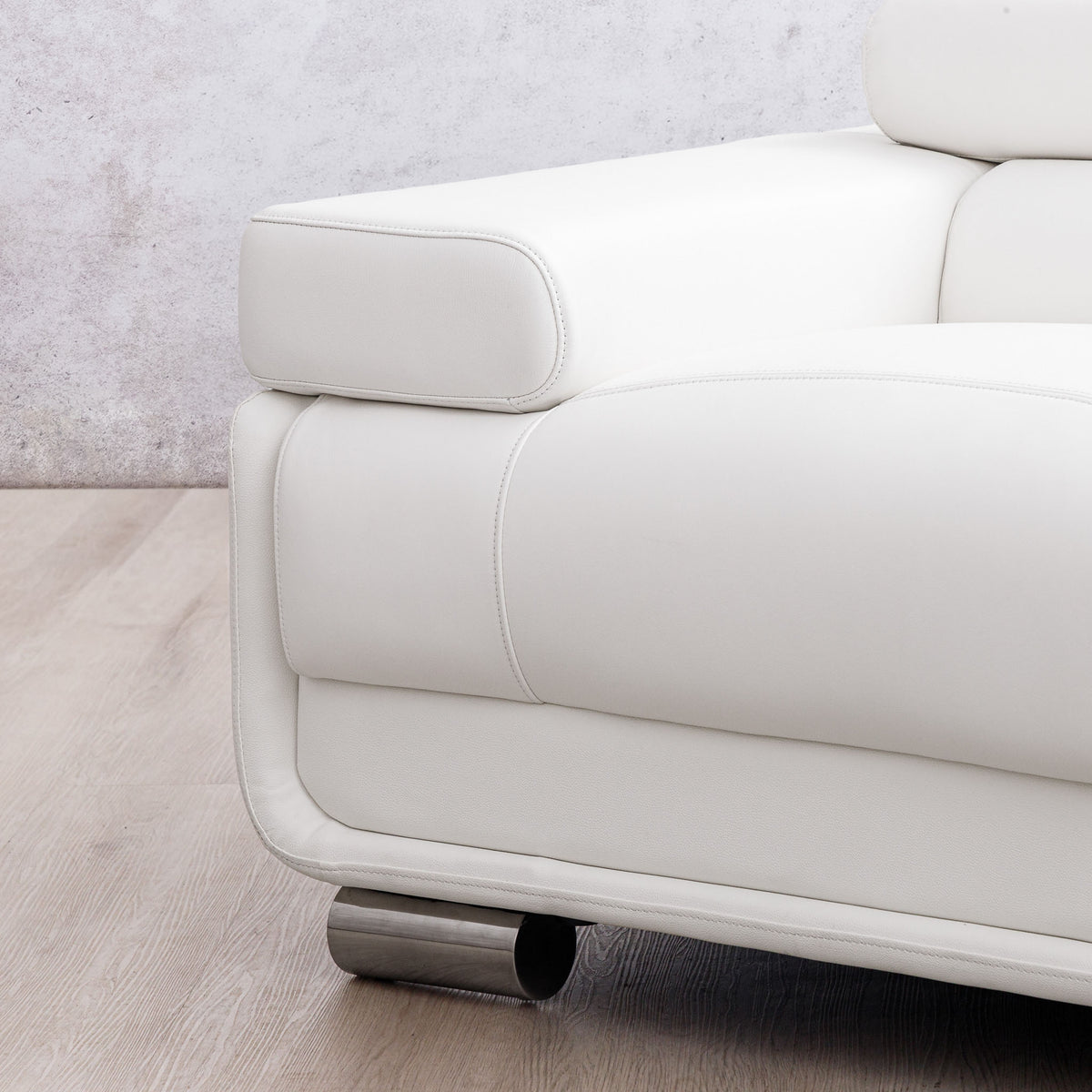 Close-up of the Leather Gallery Tobago 5 Seater L Shape Sectional in white, showing the leather corner and cylindrical metal foot.