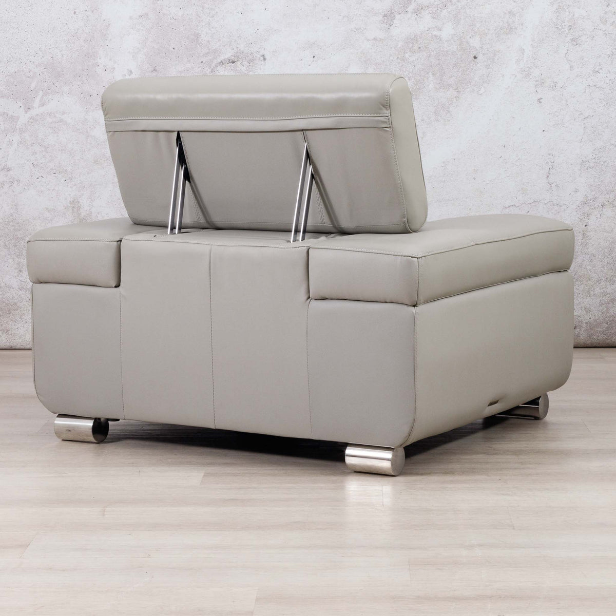 Leather Gallery Tobago 1 Seater Leather Couch in Grey, shown with the backrest lifted against a textured grey wall and light wood floor.