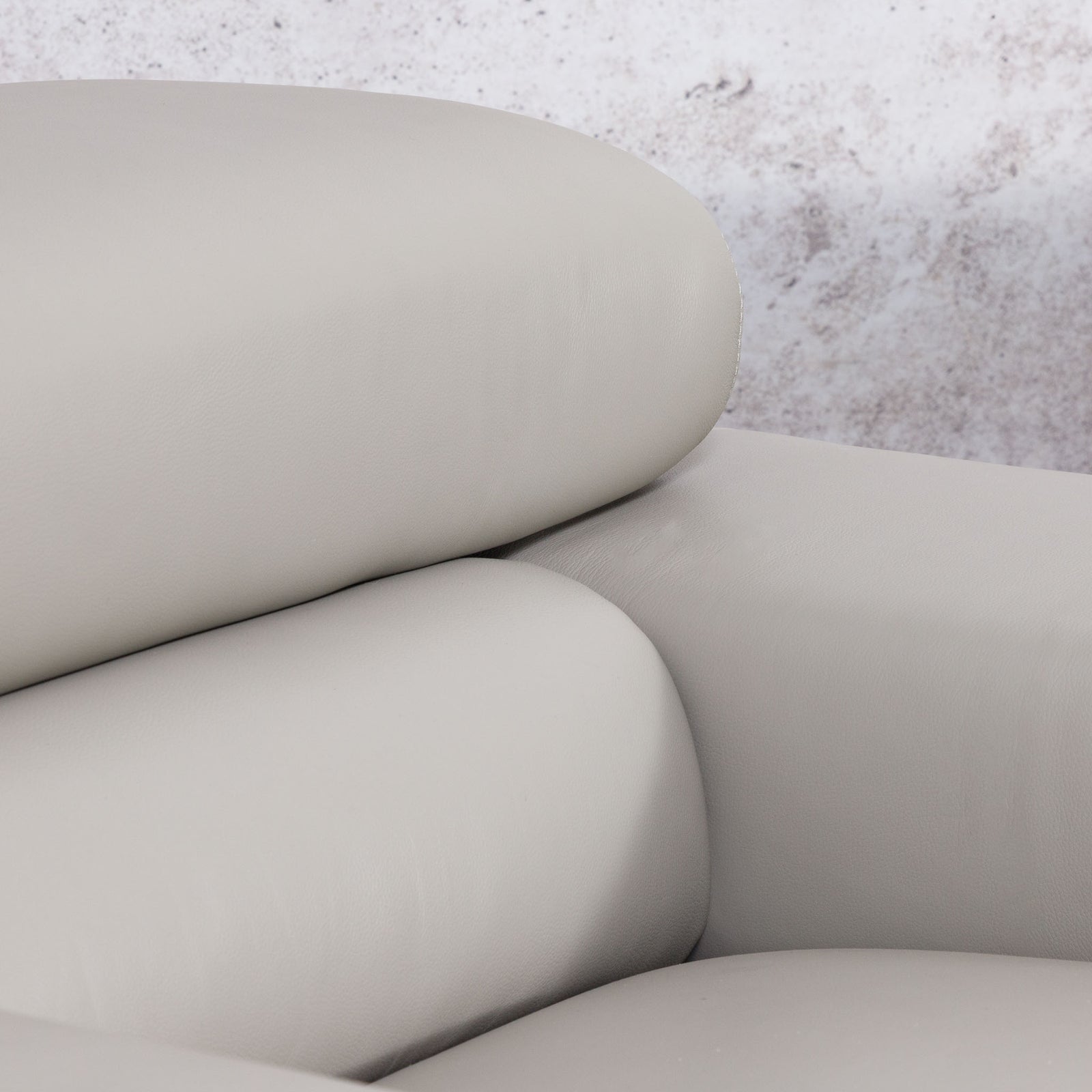 Close-up of the Leather Gallery Tobago 3 Seater Leather Couch in Grey, showing the curved seat, backrest, and armrest in smooth leather upholstery.