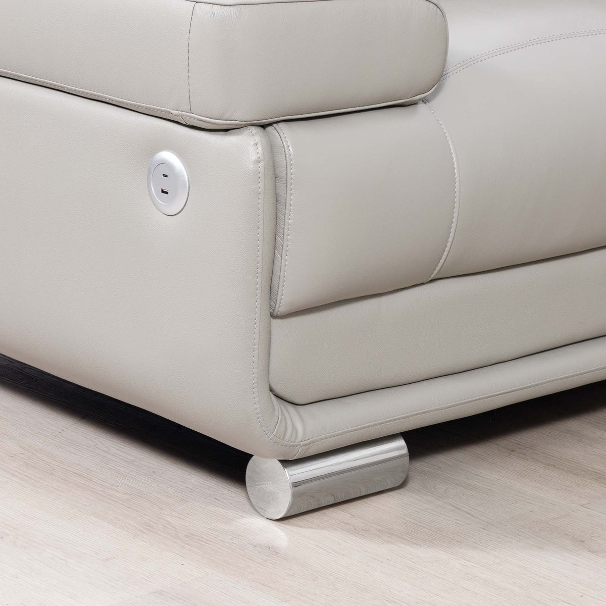 Close-up of the Leather Gallery Tobago 5 Seater Leather L Shape Couch in Grey, showing the USB and USB-C charging ports and cylindrical metal foot.