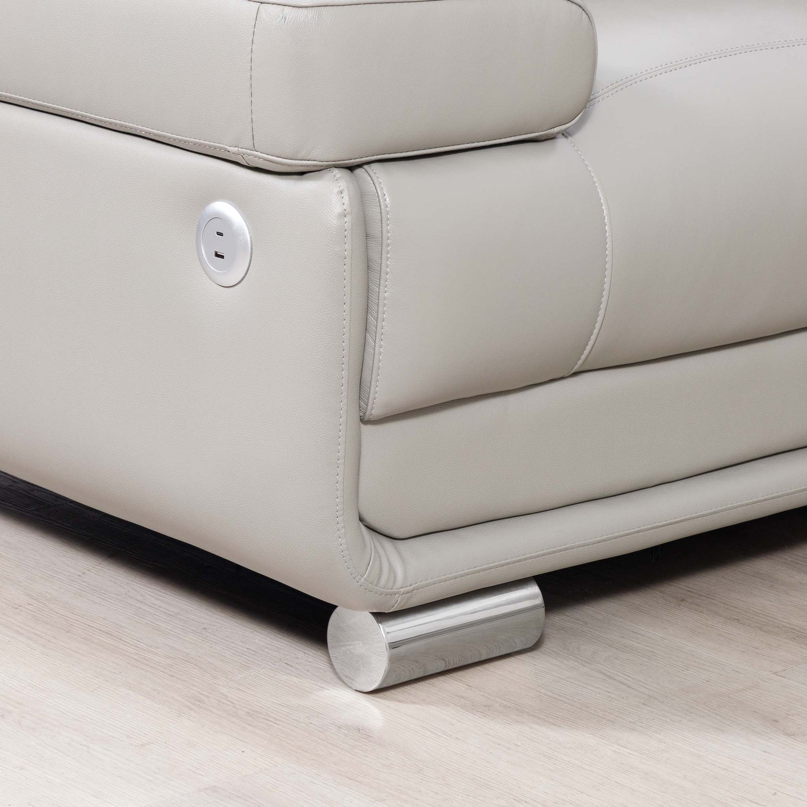 Close-up of the Leather Gallery Tobago 5 Seater Leather L Shape Couch in Grey, showing the USB and USB-C charging ports and cylindrical metal foot.