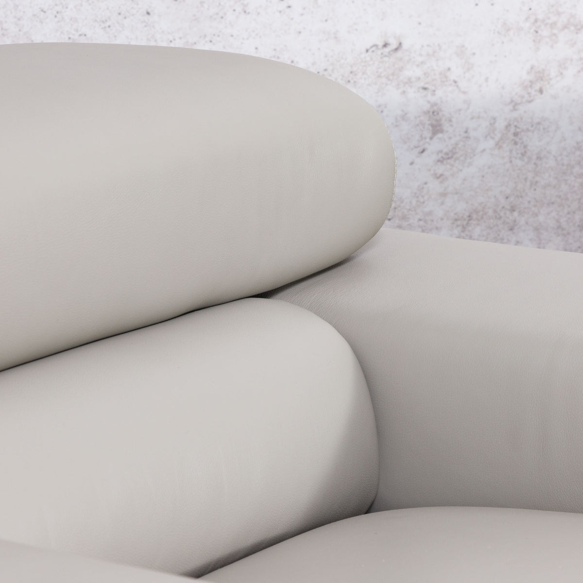 Close-up of the Leather Gallery Tobago 5 Seater Leather L Shape Couch in Grey, showing the curved seat, backrest, and armrest.