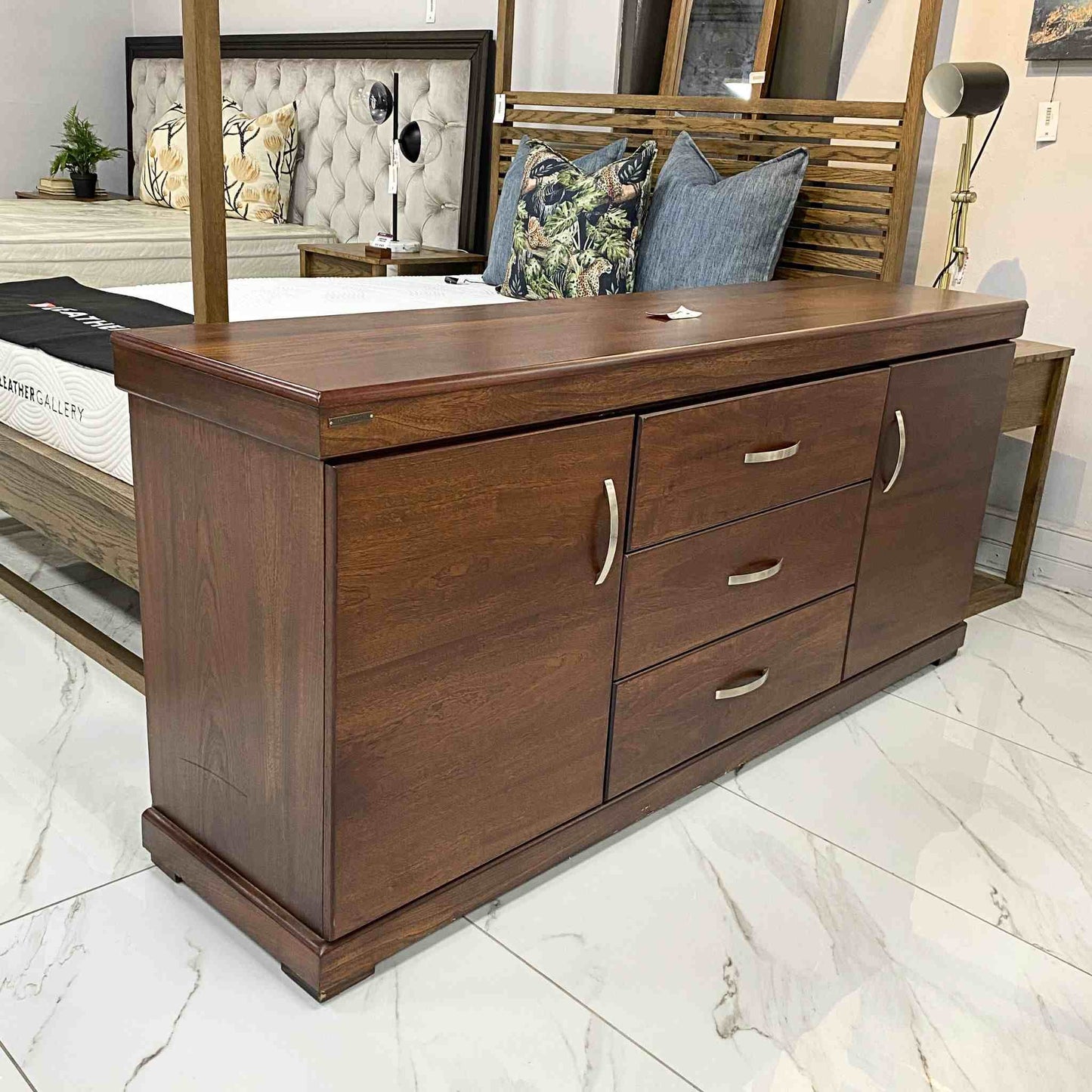 Leather Gallery Urban 2 Door + 3 Drawer Sideboard, featuring a wooden cabinet with three drawers in a styled bedroom setting.